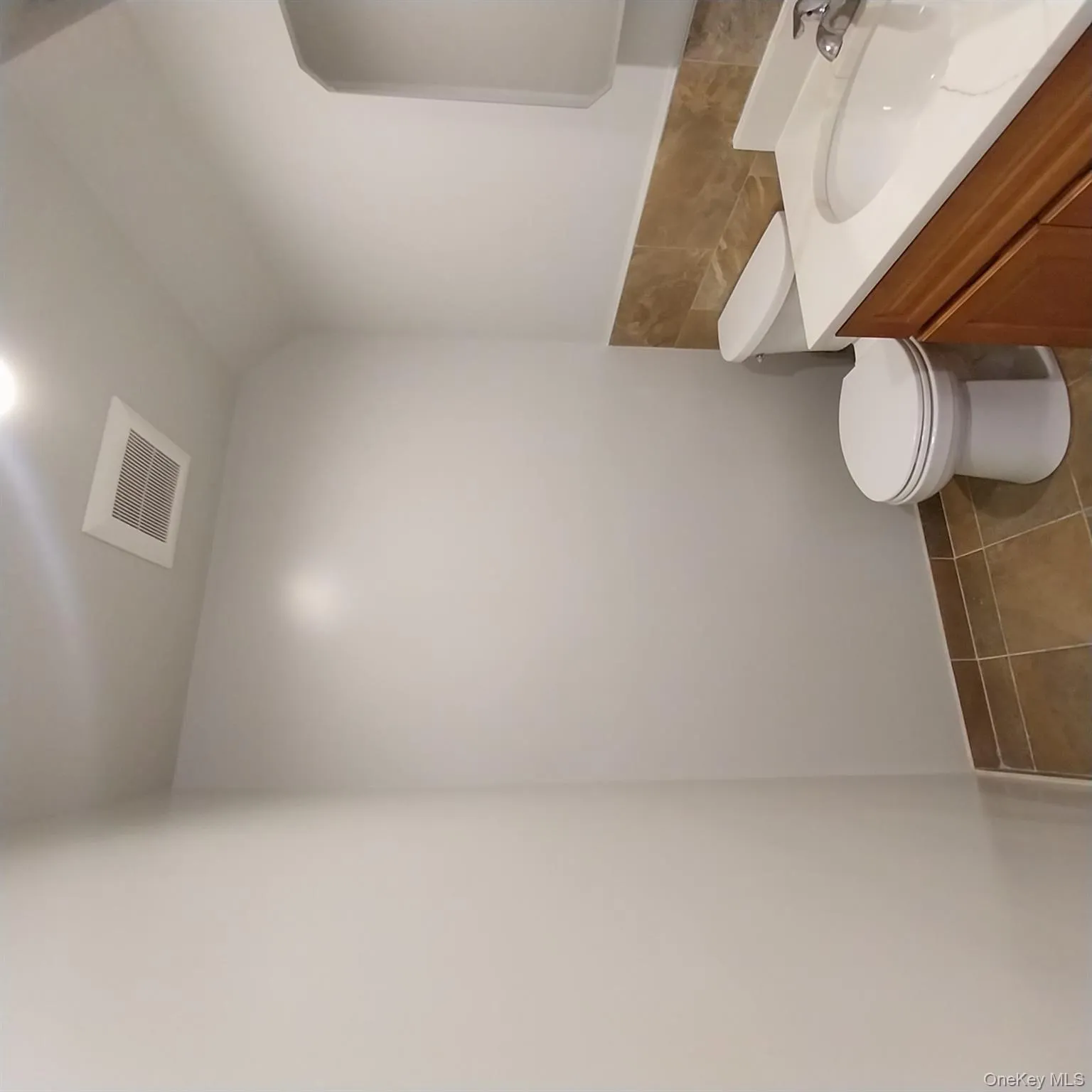 Half bathroom featuring vanity, dark tile patterned flooring, and tile walls Half bathroom featuring vanity, dark tile patterned flooring, and tile walls
