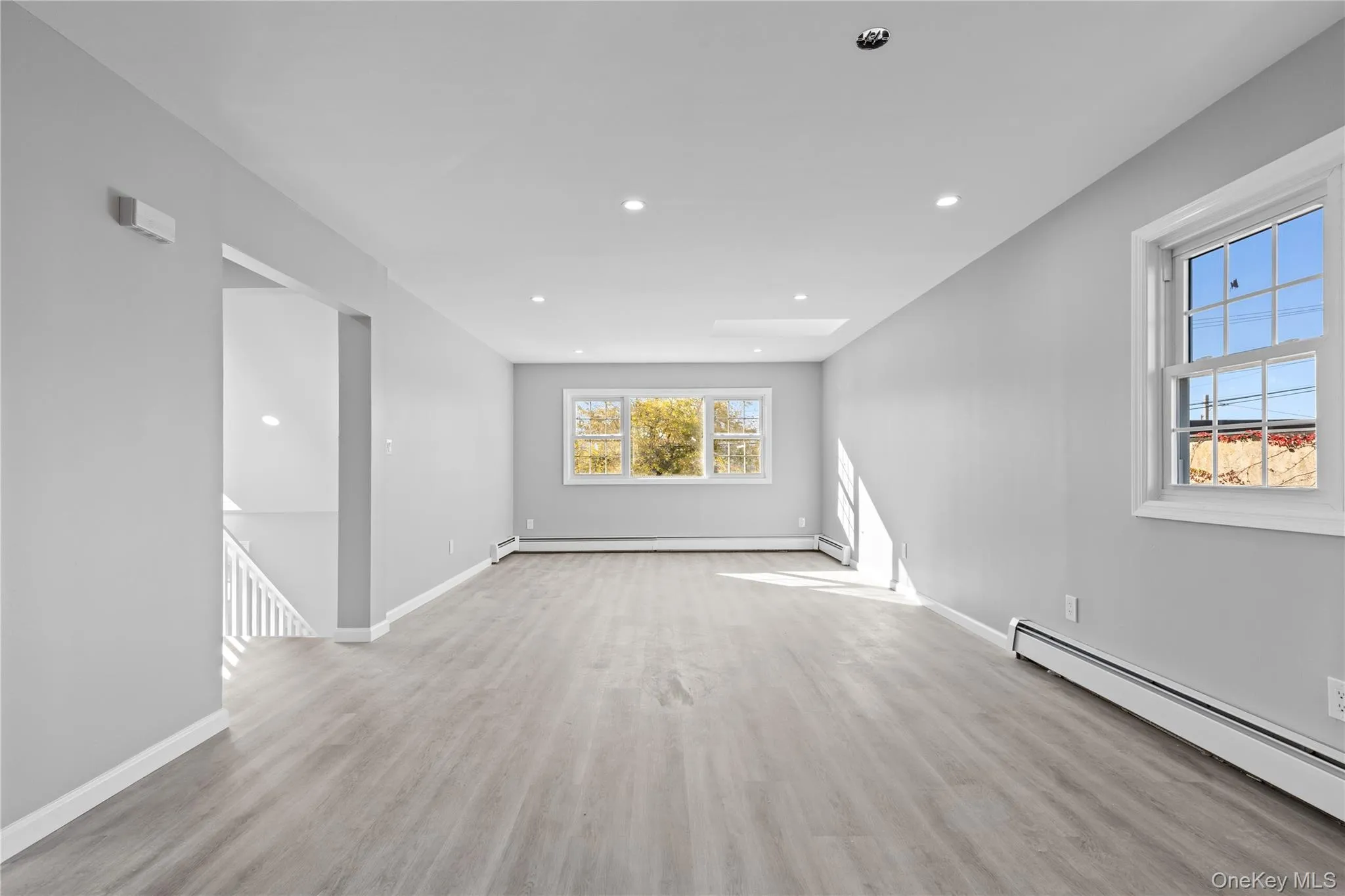 Spare room with baseboard heating, light wood-type flooring, and recessed lighting Spare room with baseboard heating, light wood-type flooring, and recessed lighting