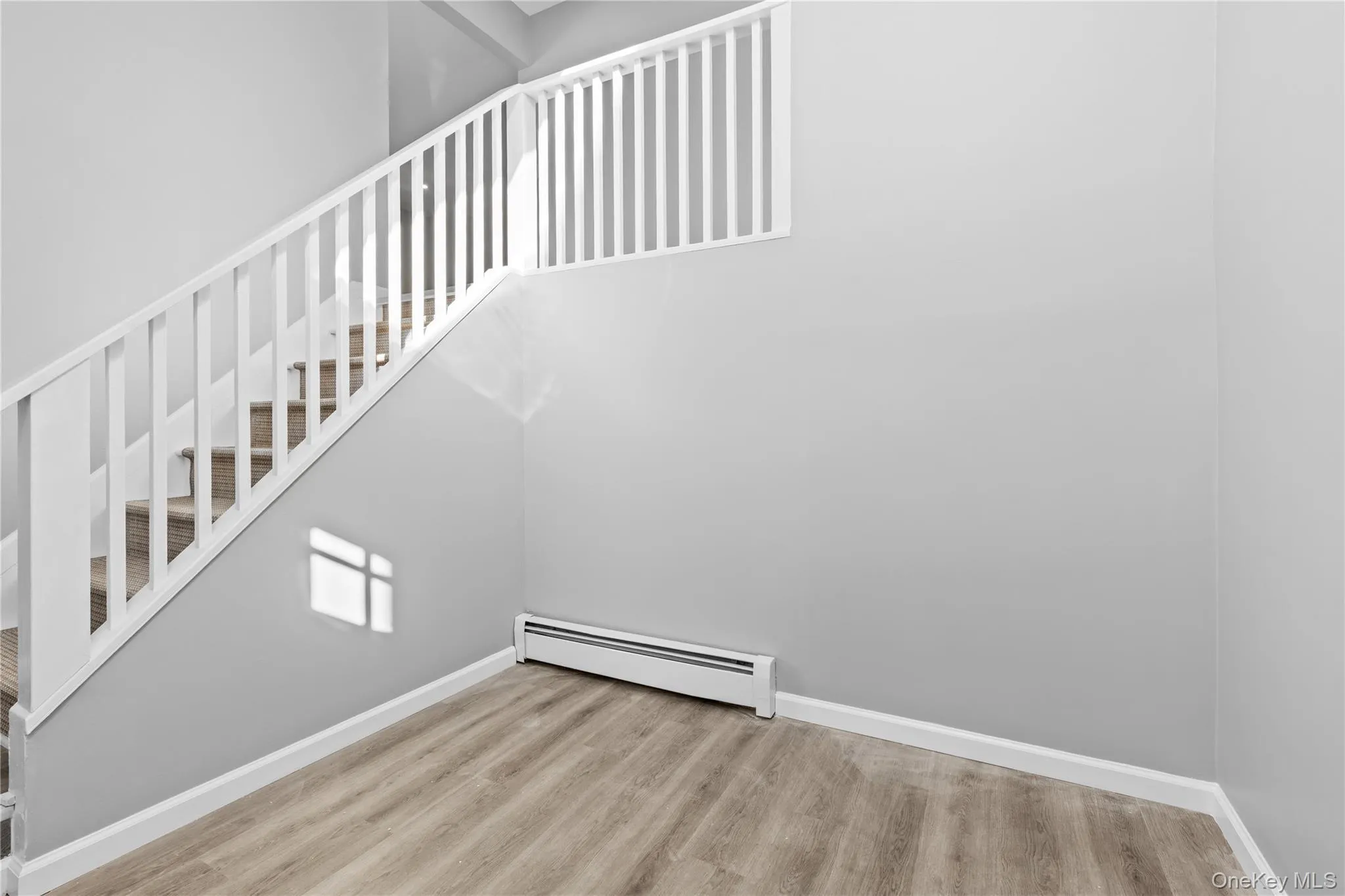 Stairway featuring wood finished floors and baseboard heating Stairway featuring wood finished floors and baseboard heating