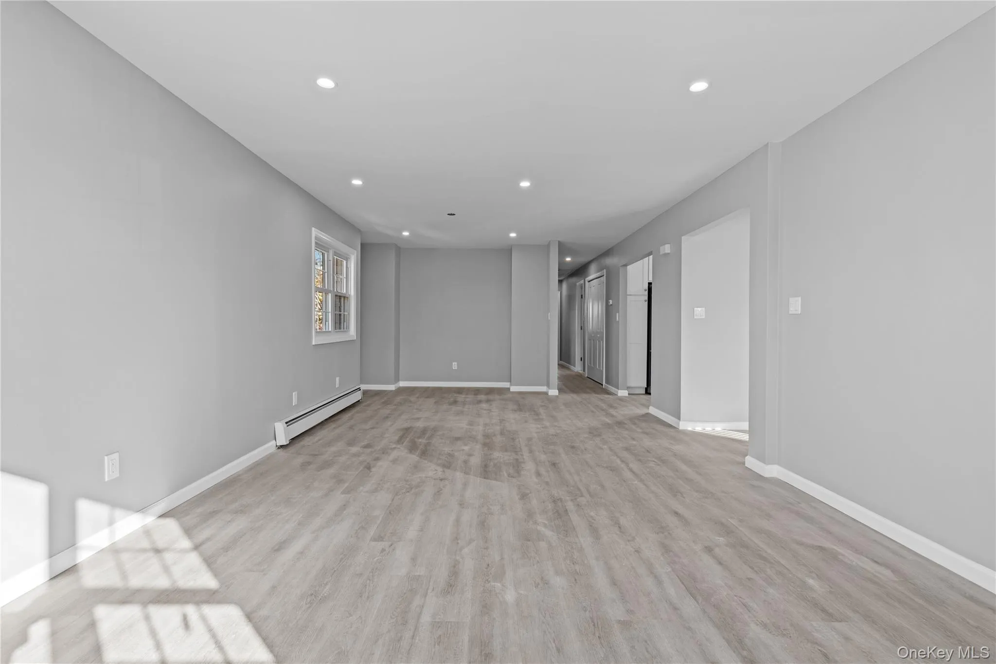 Unfurnished room featuring light wood finished floors, recessed lighting, and a baseboard radiator Unfurnished room featuring light wood finished floors, recessed lighting, and a baseboard radiator