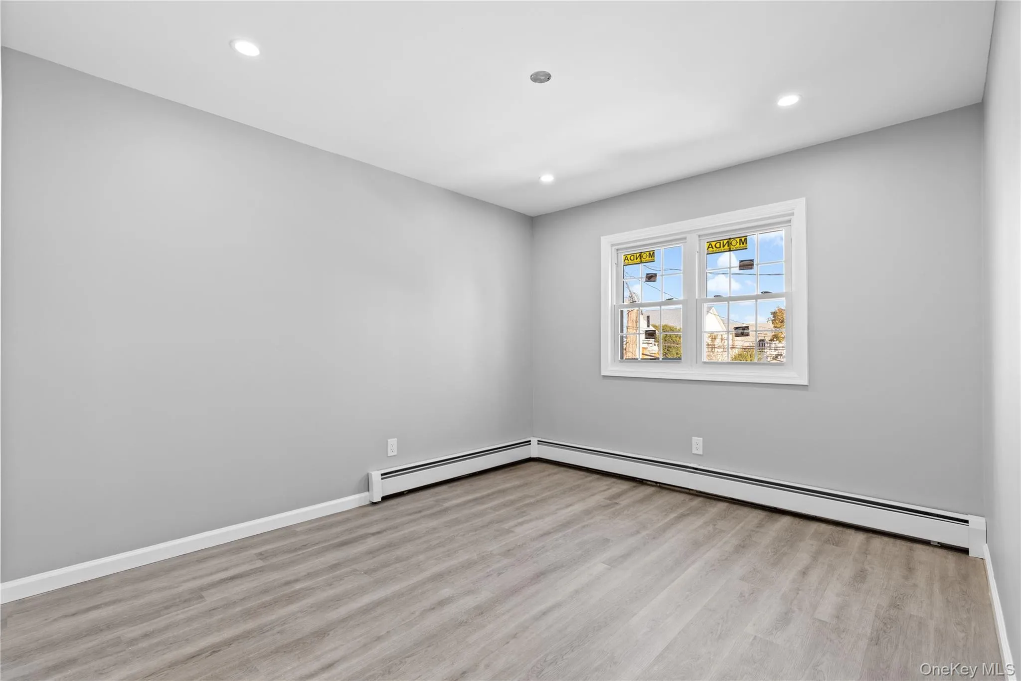 Unfurnished room with light wood-type flooring, baseboard heating, and recessed lighting Unfurnished room with light wood-type flooring, baseboard heating, and recessed lighting