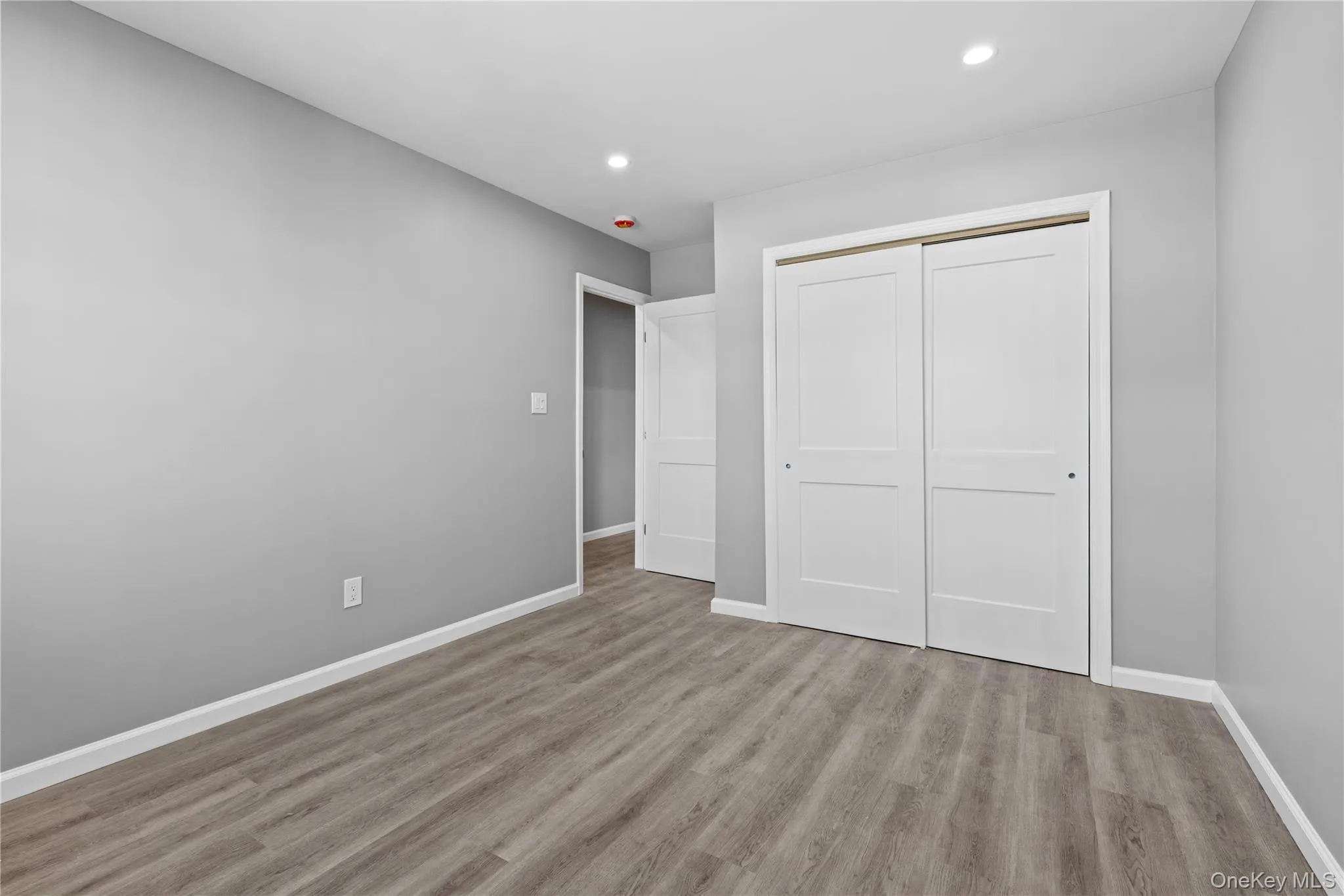 Unfurnished bedroom with recessed lighting, light wood finished floors, and a closet Unfurnished bedroom with recessed lighting, light wood finished floors, and a closet