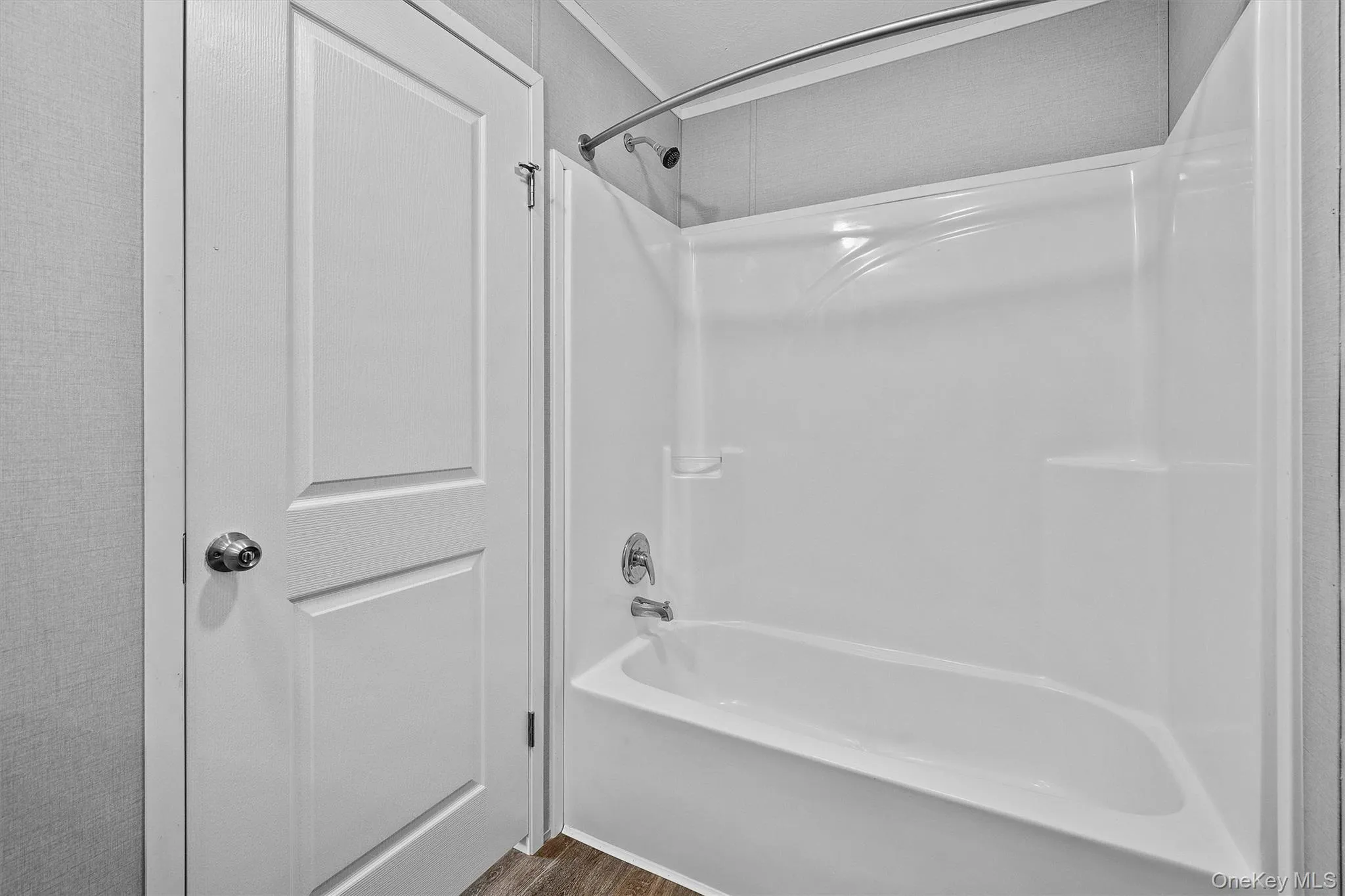 Full bathroom with shower combination and wood finished floors Full bathroom with shower combination and wood finished floors