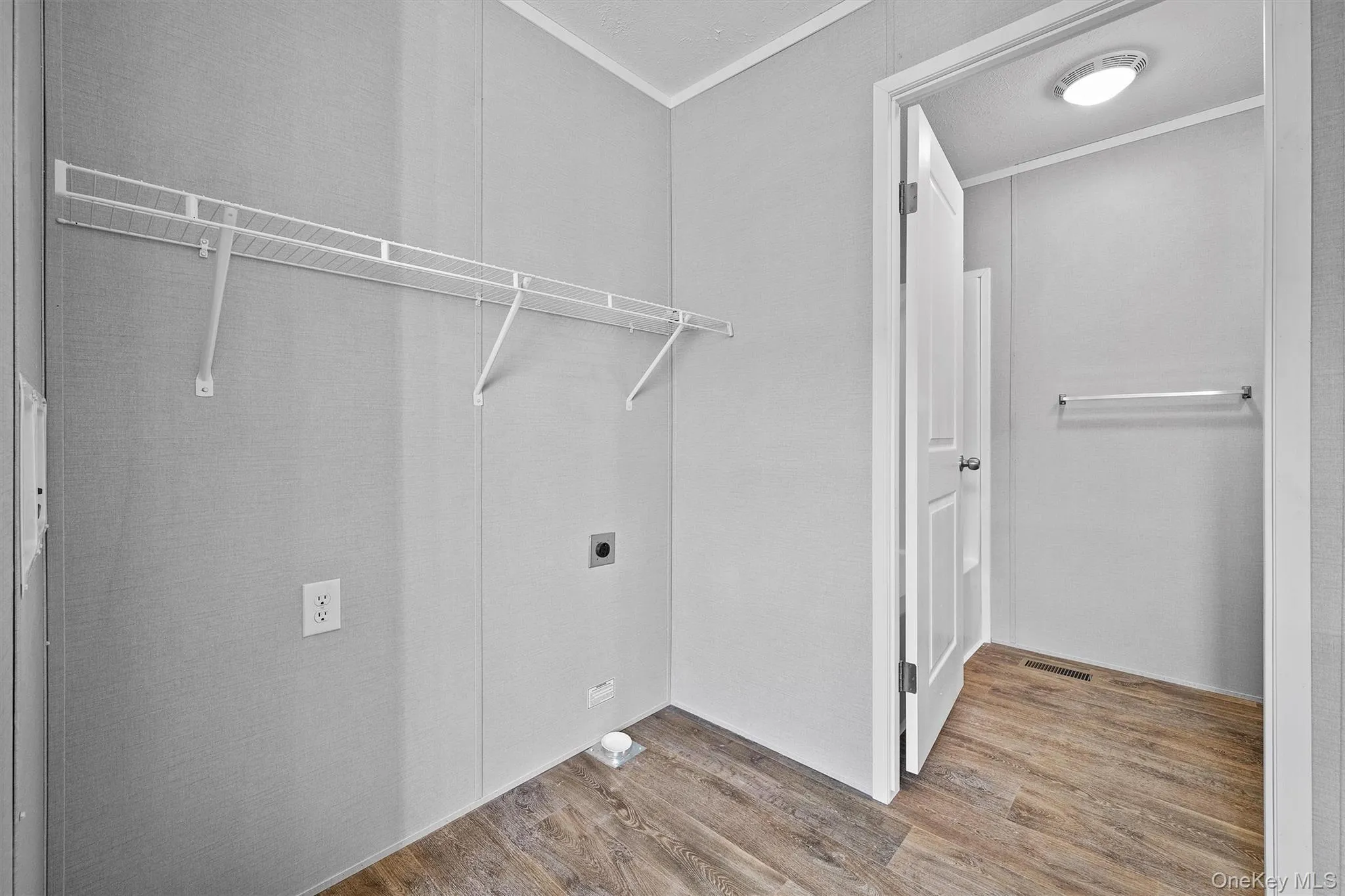Clothes washing area with laundry area, wood finished floors, hookup for an electric dryer, and visible vents Clothes washing area with laundry area, wood finished floors, hookup for an electric dryer, and visible vents