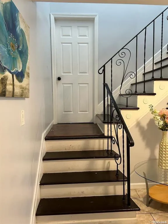 Stairway with baseboards and tile patterned floors Stairway with baseboards and tile patterned floors