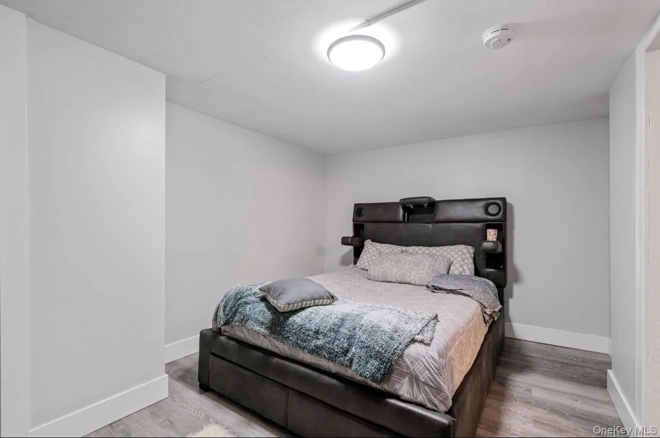 Bedroom featuring baseboards and wood finished floors Bedroom featuring baseboards and wood finished floors