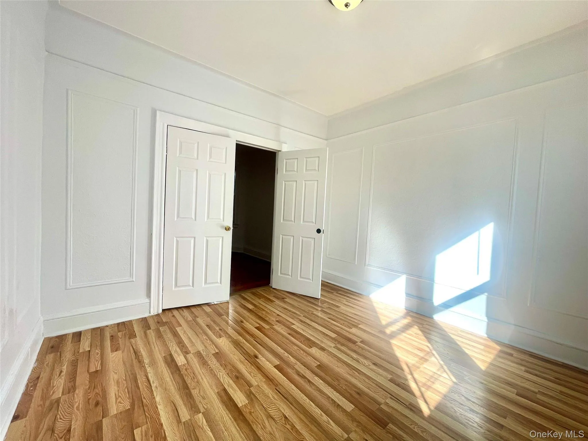 Unfurnished room featuring a decorative wall and light wood-style floors Unfurnished room featuring a decorative wall and light wood-style floors