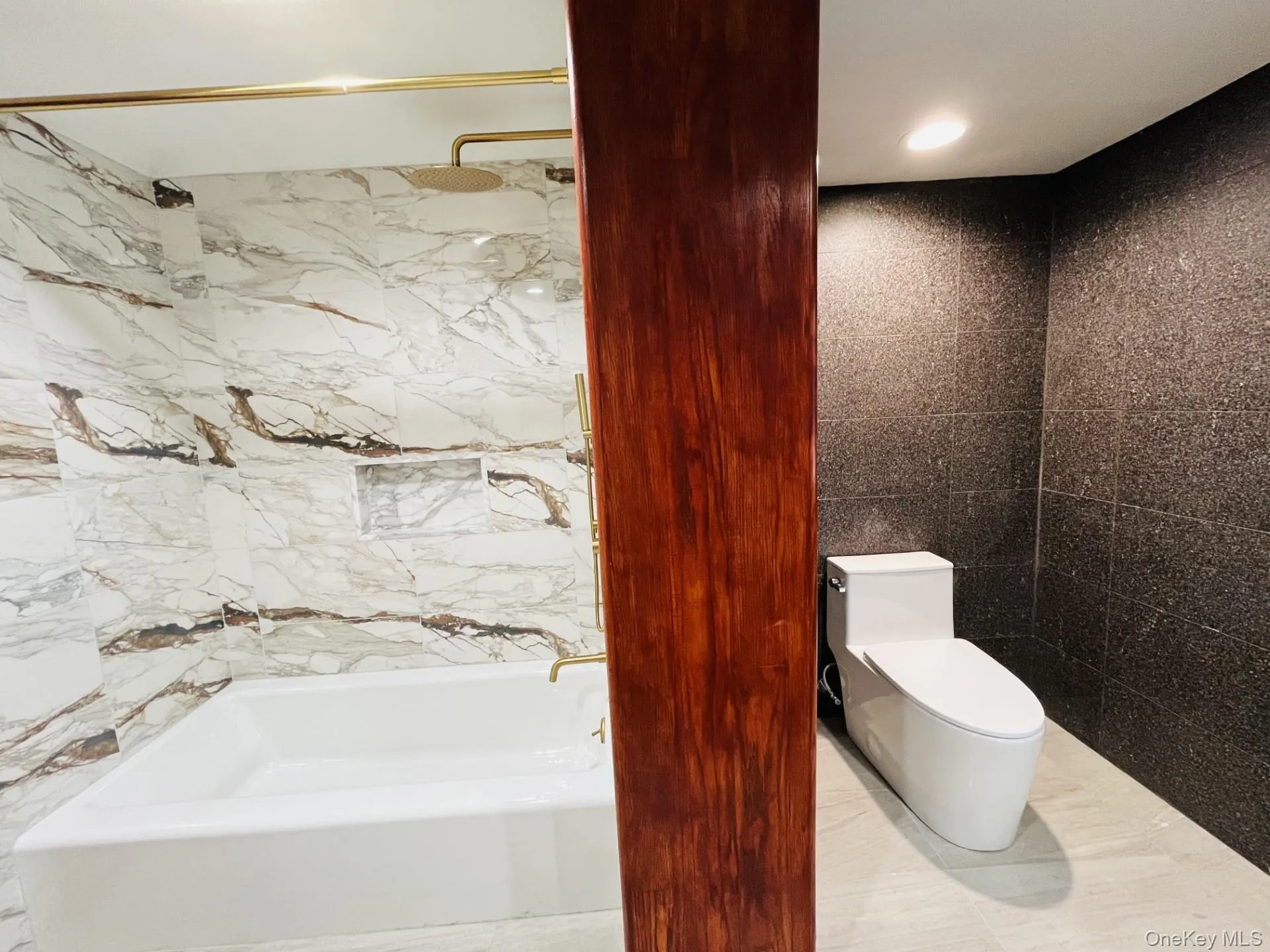 New full bathroom featuring tile walls, a combined bath / shower with rain shower head and recessed lighting New full bathroom featuring tile walls, a combined bath / shower with rain shower head and recessed lighting