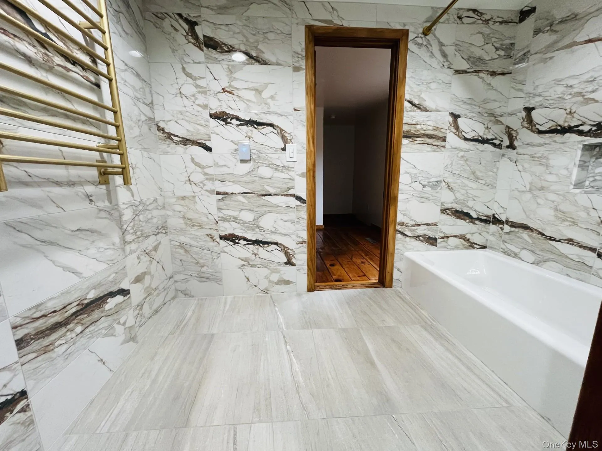 Large marble bathroom with tub and a towel warming rack Large marble bathroom with tub and a towel warming rack