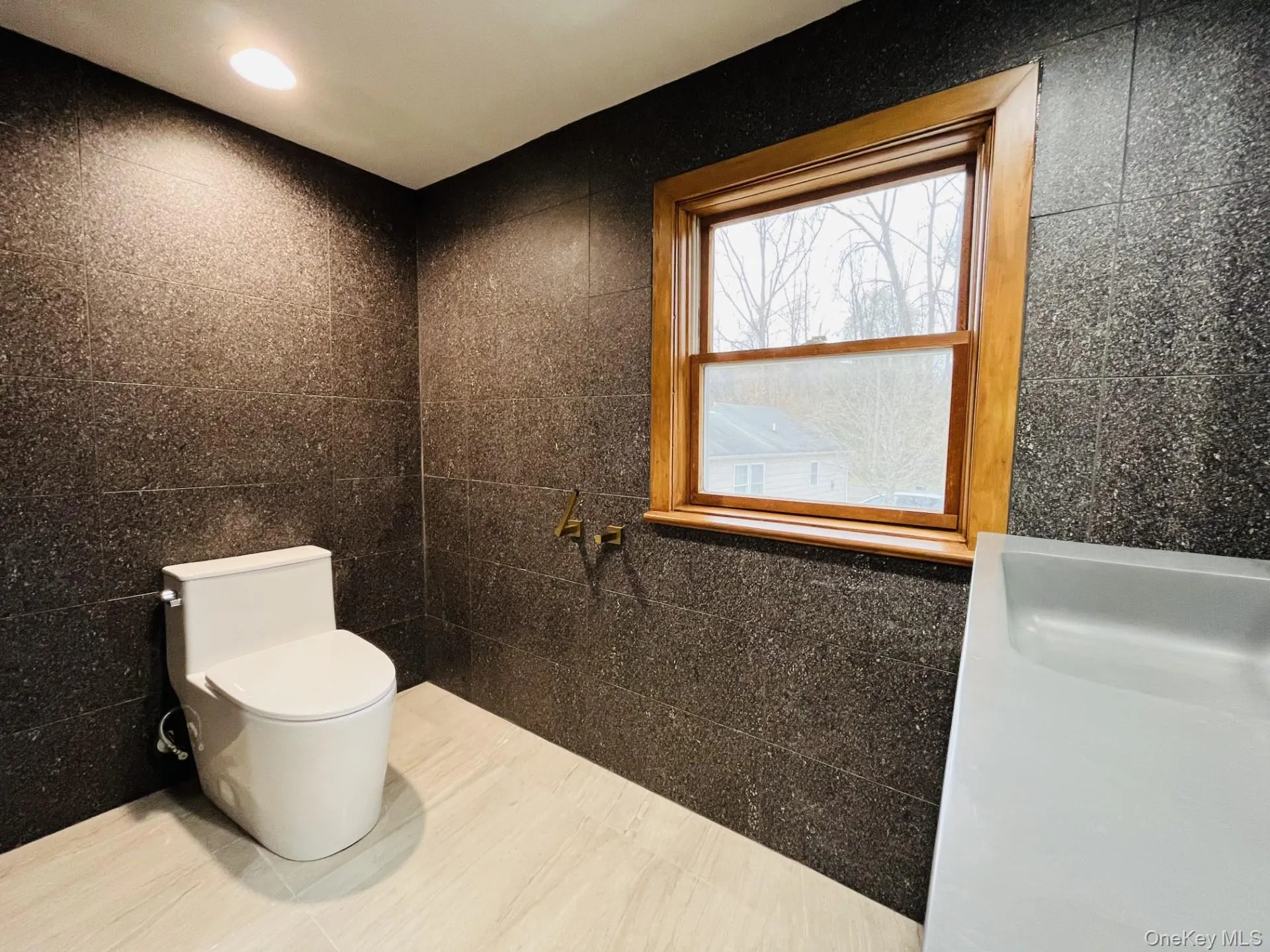 Bathroom featuring tile walls, tile patterned floors, and recessed lighting Bathroom featuring tile walls, tile patterned floors, and recessed lighting