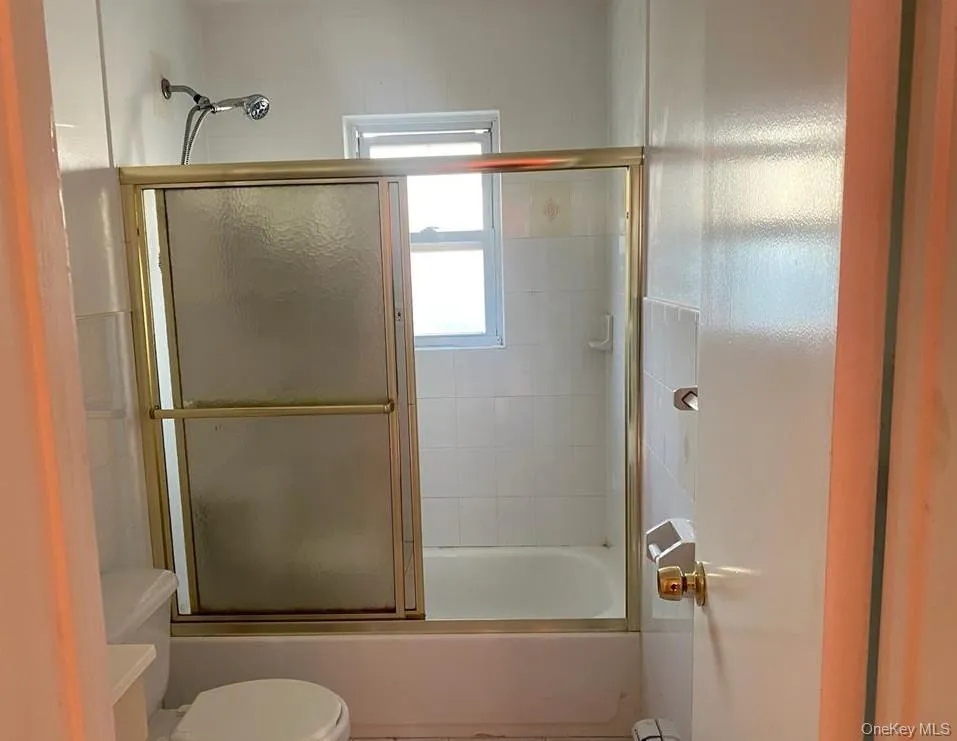 Bathroom with shower / bath combination with glass door and toilet Bathroom with shower / bath combination with glass door and toilet