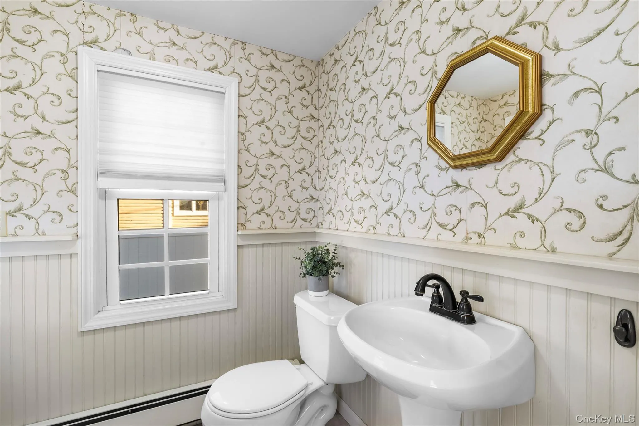 Bathroom with wallpapered walls and a baseboard radiator Bathroom with wallpapered walls and a baseboard radiator