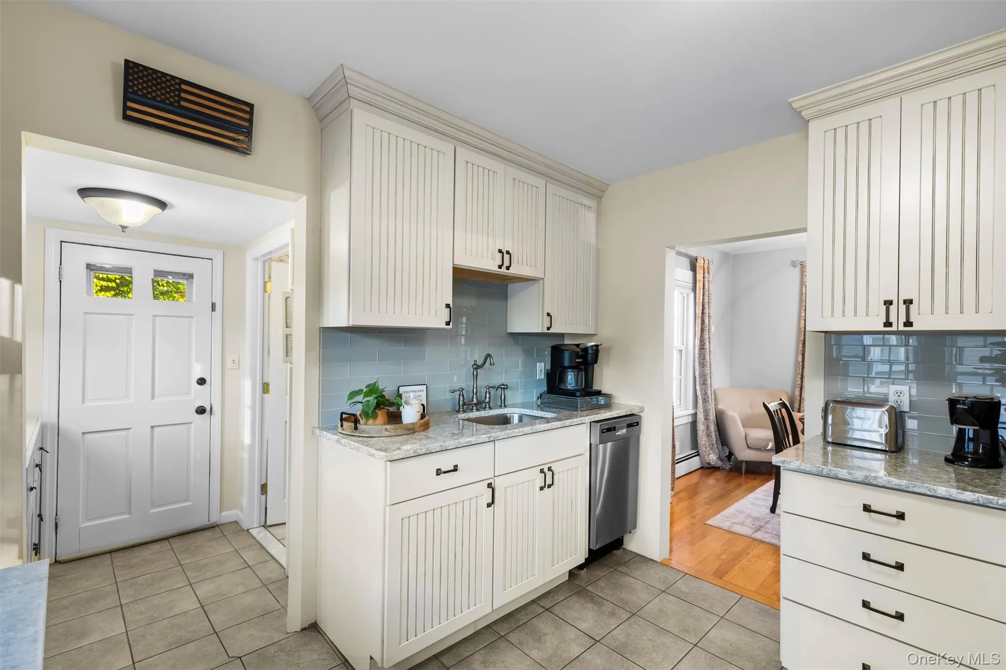 Kitchen featuring light tile patterned flooring, light stone counters, dishwasher, and decorative backsplash Kitchen featuring light tile patterned flooring, light stone counters, dishwasher, and decorative backsplash