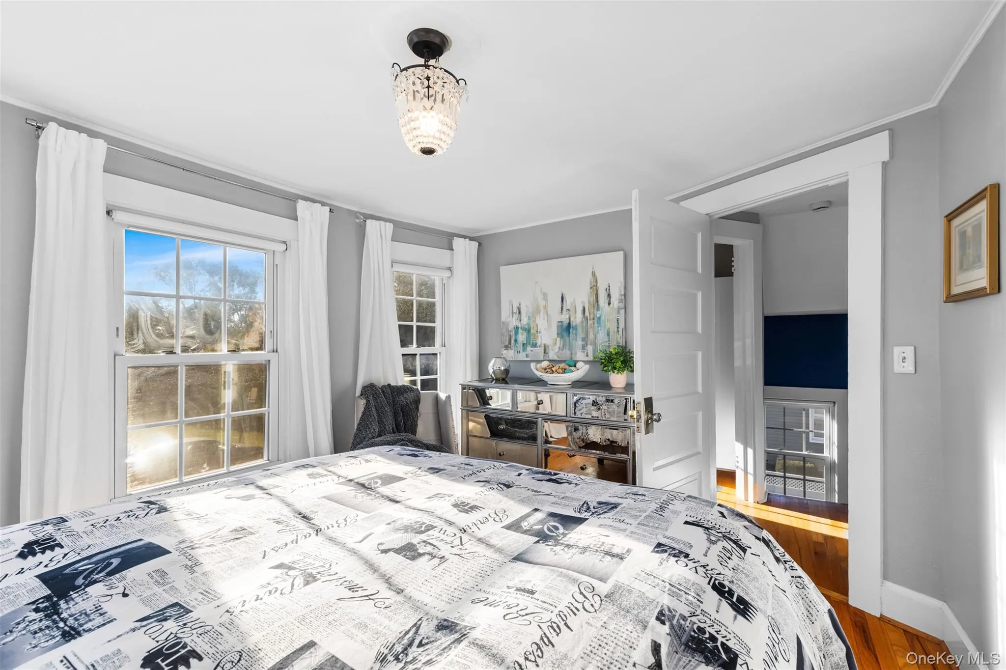 Bedroom featuring wood finished floors and ornamental molding Bedroom featuring wood finished floors and ornamental molding