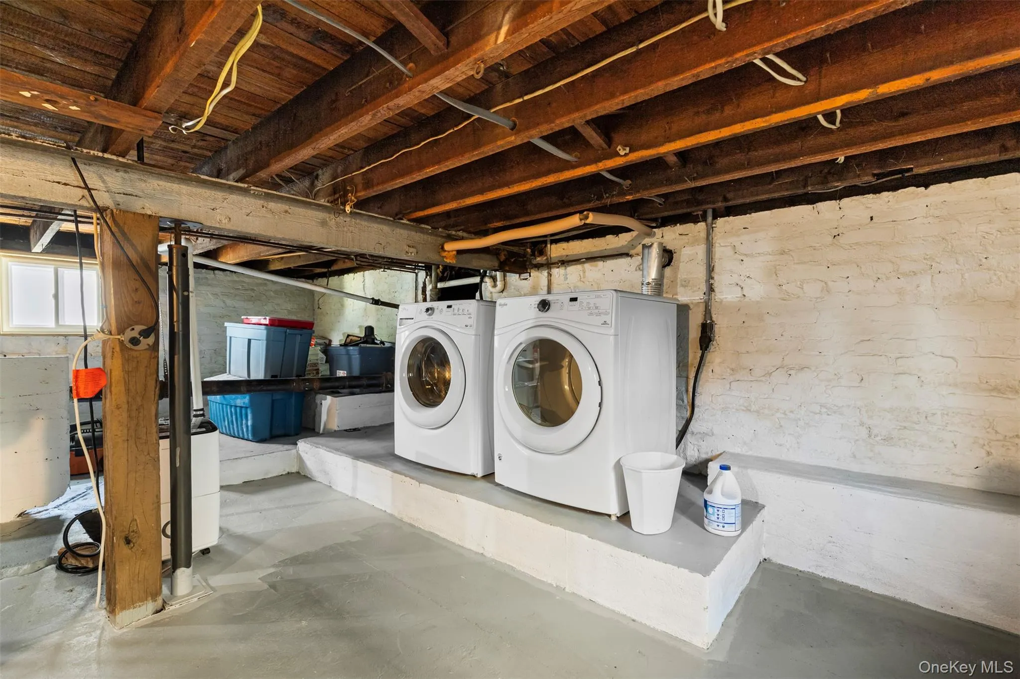 Laundry area featuring washer and clothes dryer and concrete floors Laundry area featuring washer and clothes dryer and concrete floors