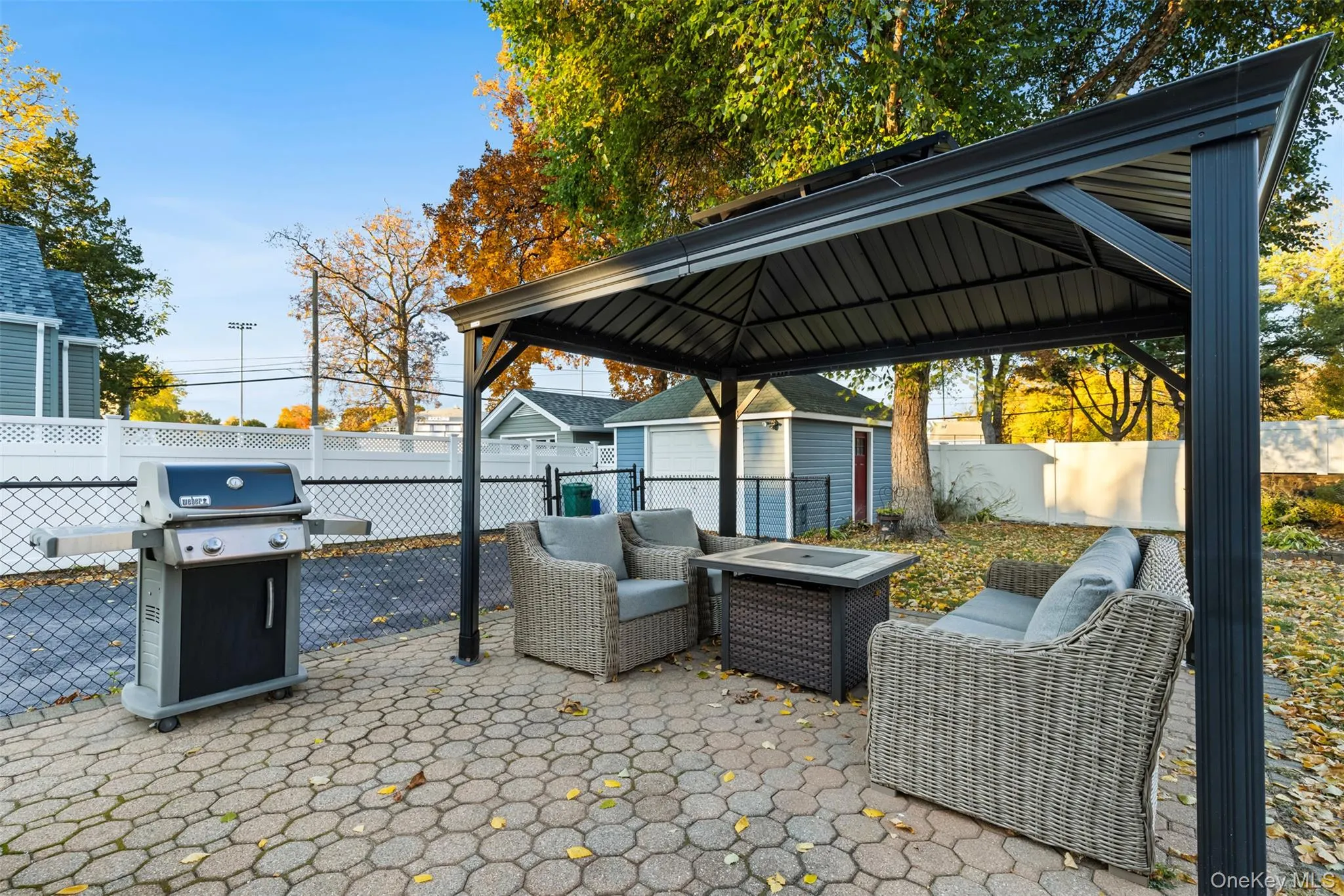 Fenced backyard with a patio, a gazebo, area for grilling, an outdoor structure, and an outdoor living space Fenced backyard with a patio, a gazebo, area for grilling, an outdoor structure, and an outdoor living space
