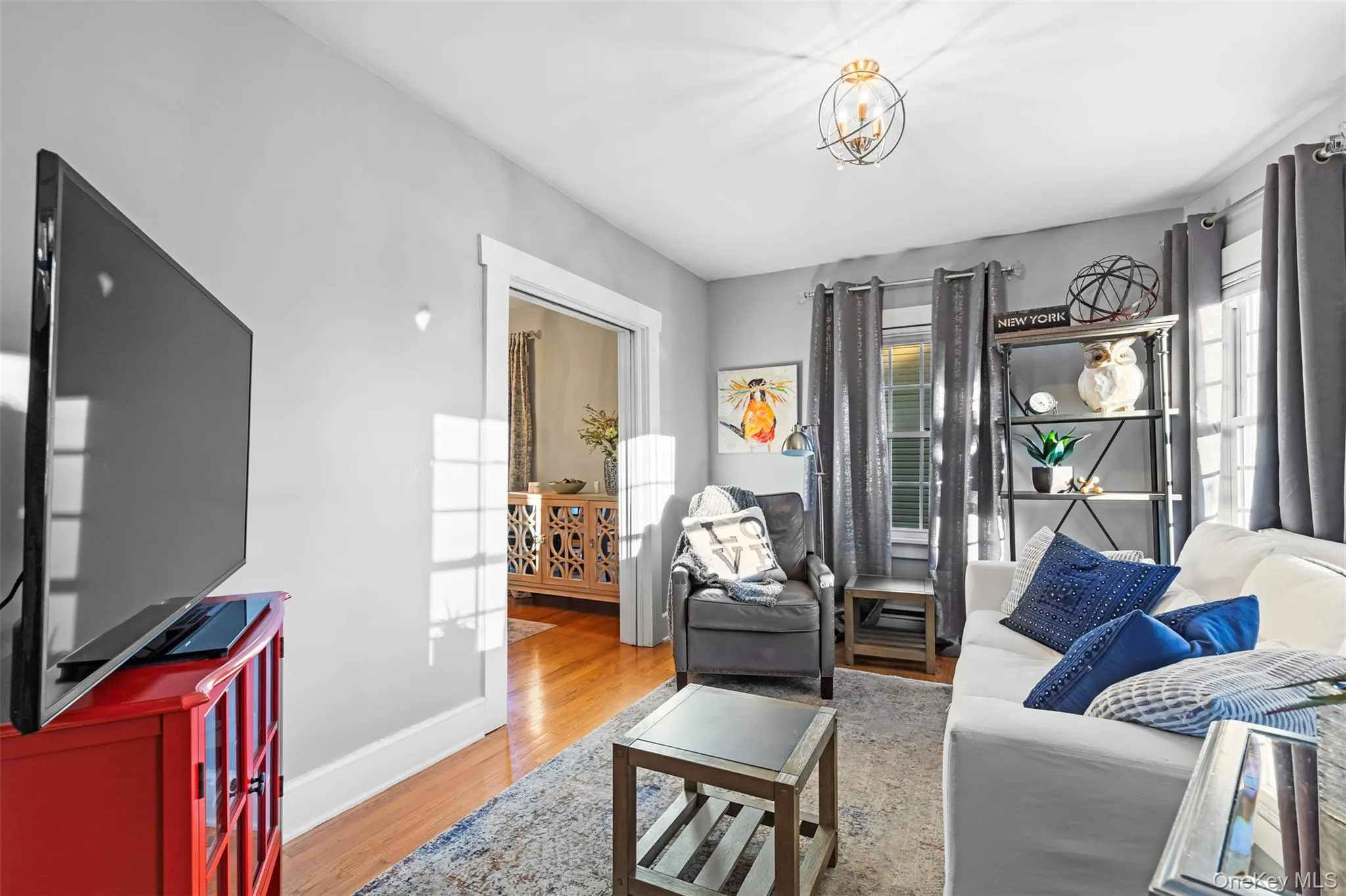Living room featuring light wood-style floors and a chandelier Living room featuring light wood-style floors and a chandelier