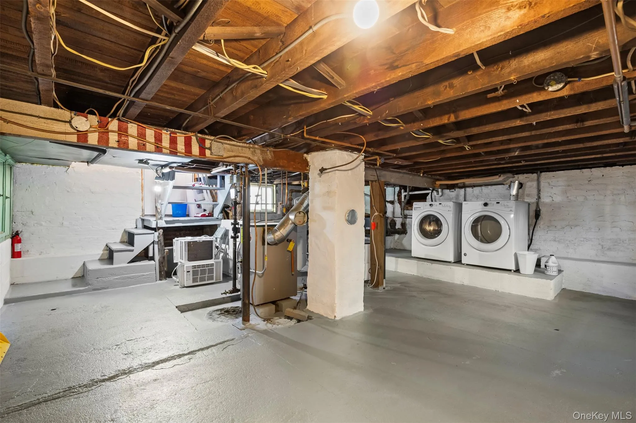 Unfinished basement with stairway and separate washer and dryer Unfinished basement with stairway and separate washer and dryer