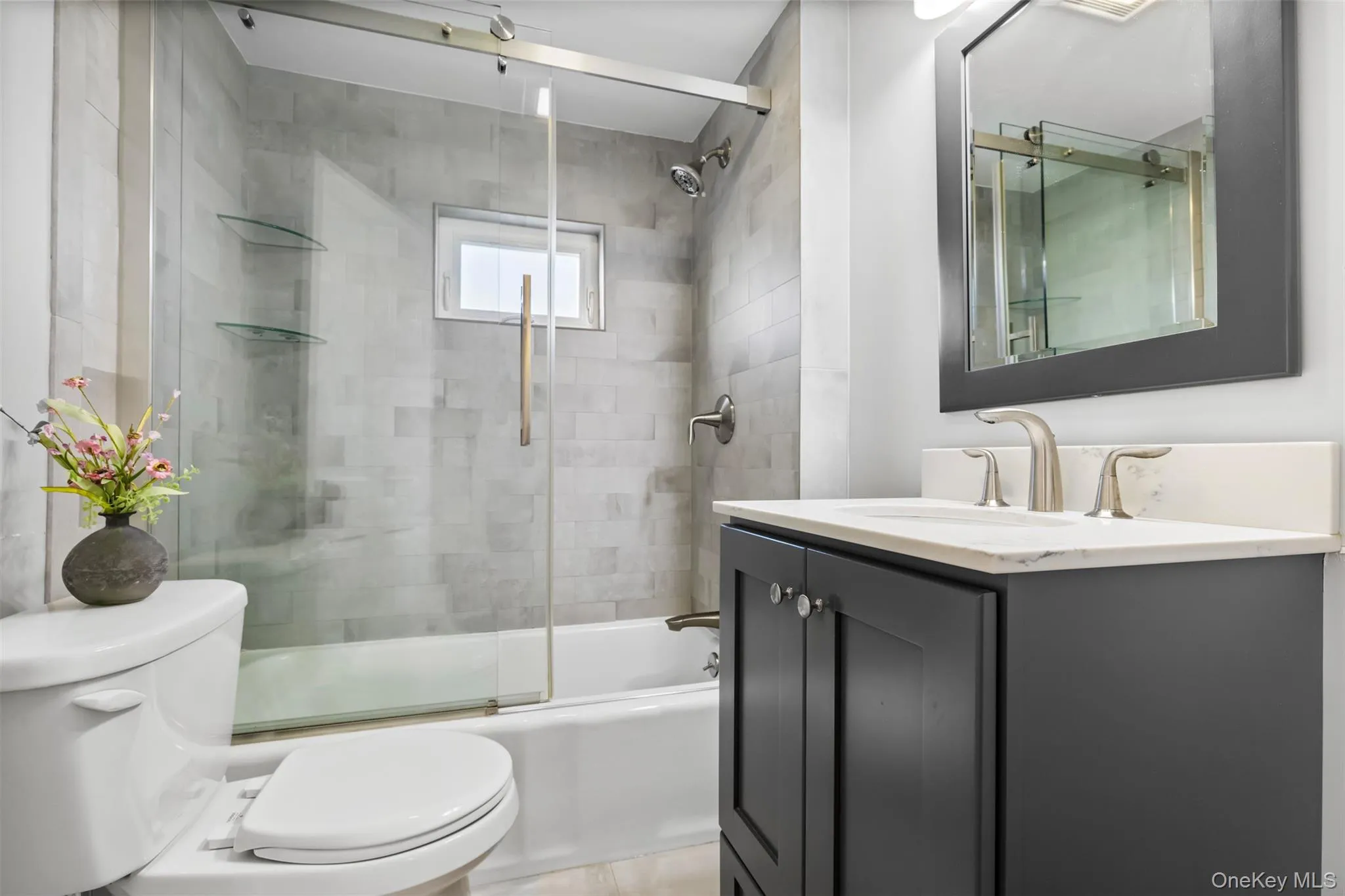 Full bathroom featuring vanity and bath / shower combo with glass door Full bathroom featuring vanity and bath / shower combo with glass door