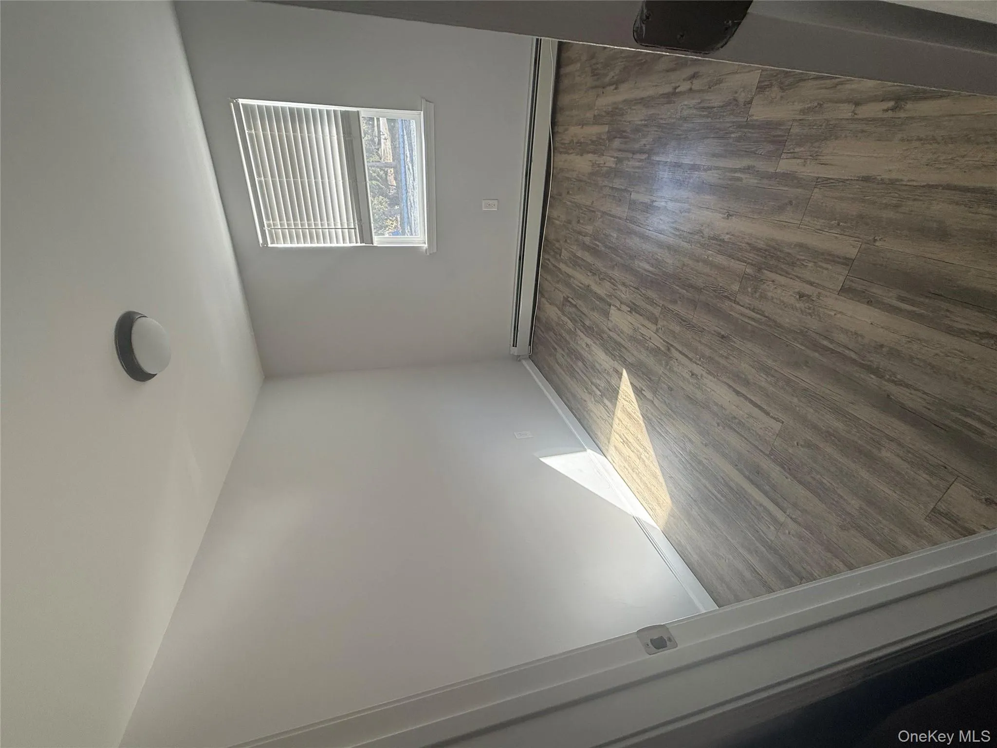 Empty room with a baseboard heating unit and dark wood-style floors Empty room with a baseboard heating unit and dark wood-style floors