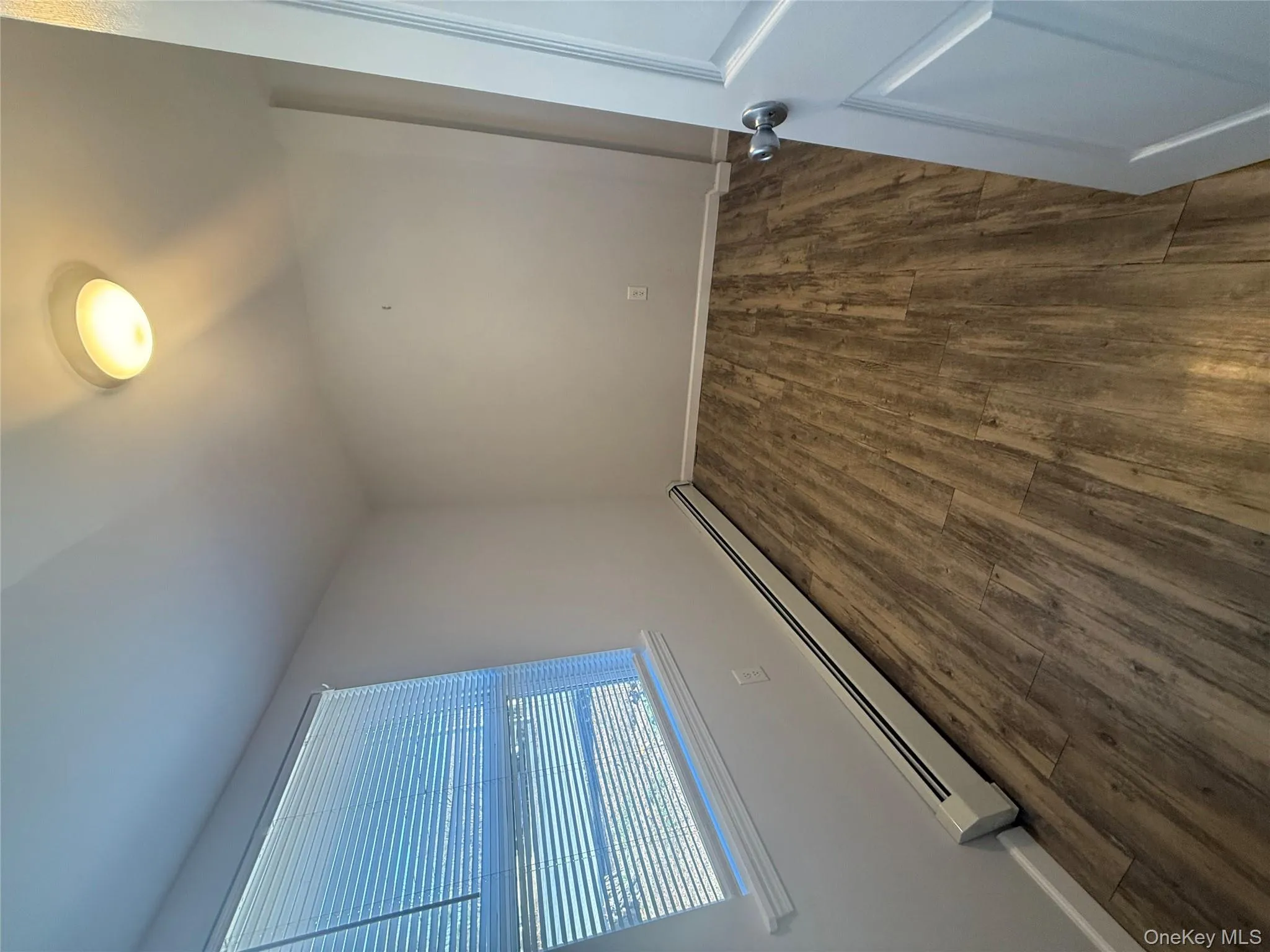 Unfurnished room with a baseboard radiator and dark wood finished floors Unfurnished room with a baseboard radiator and dark wood finished floors