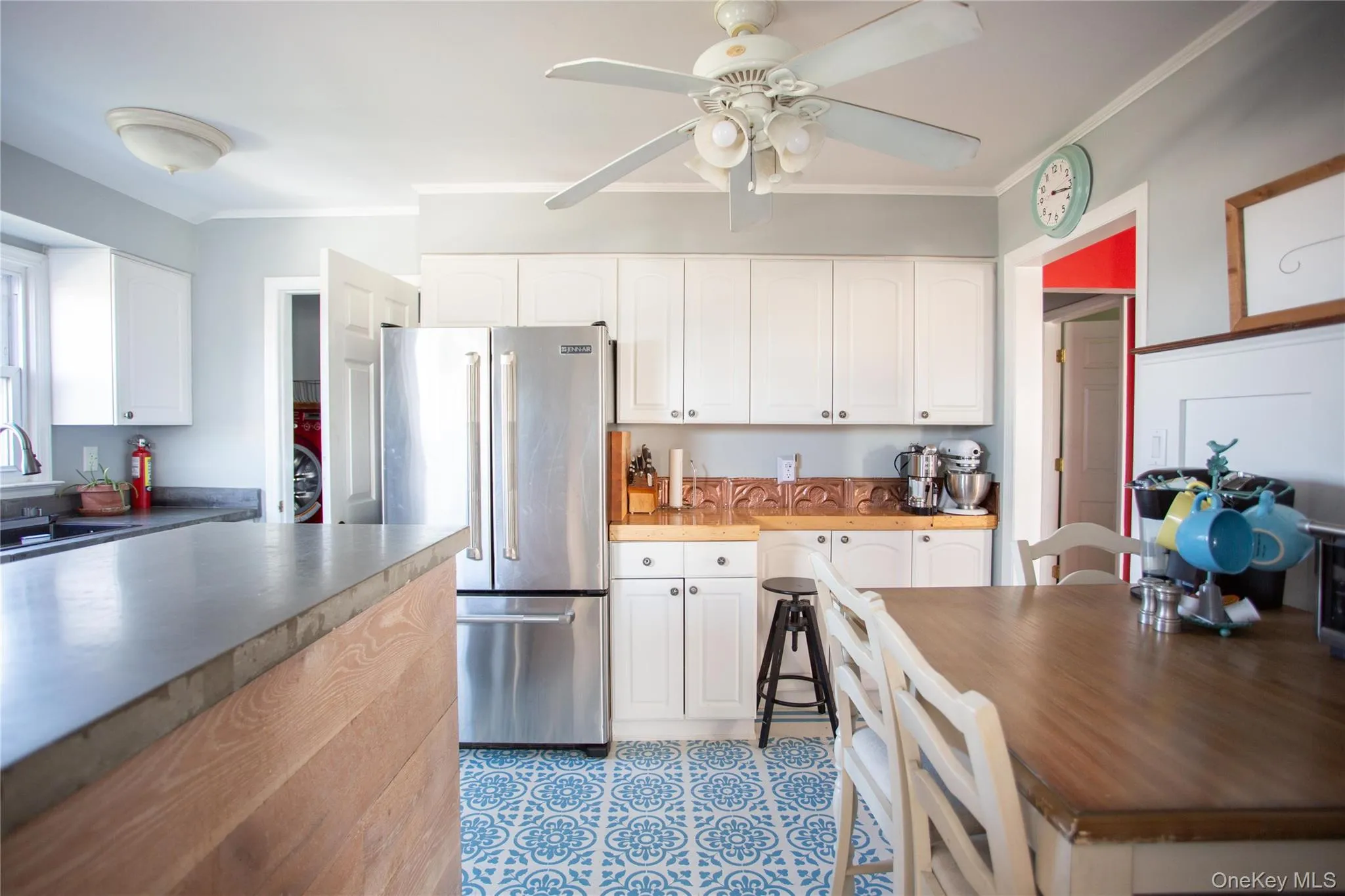 Kitchen featuring high end refrigerator, ornamental molding, white cabinets, and ceiling fan Kitchen featuring high end refrigerator, ornamental molding, white cabinets, and ceiling fan