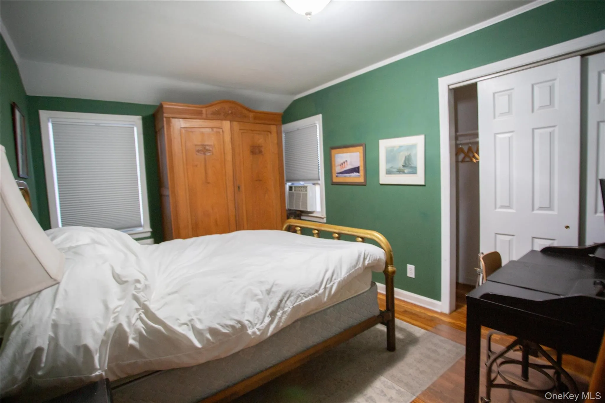 Bedroom featuring wood finished floors, a closet, and ornamental molding Bedroom featuring wood finished floors, a closet, and ornamental molding