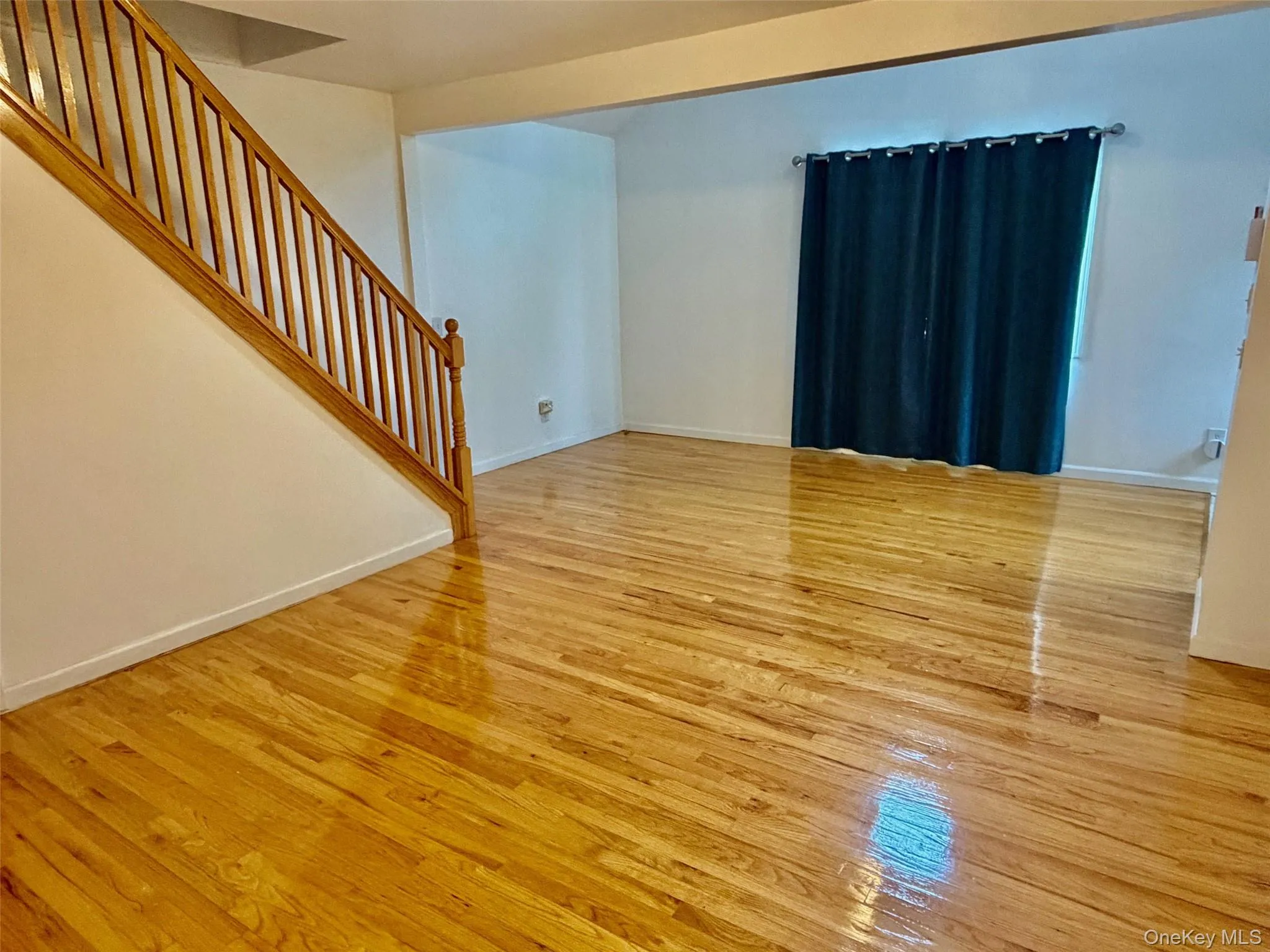Unfurnished living room with light wood-type flooring and stairway Unfurnished living room with light wood-type flooring and stairway