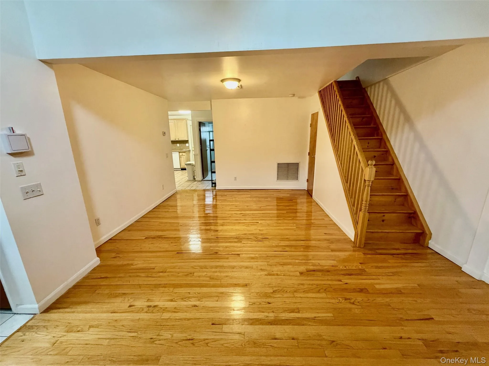 Unfurnished living room with light wood-type flooring and stairway Unfurnished living room with light wood-type flooring and stairway