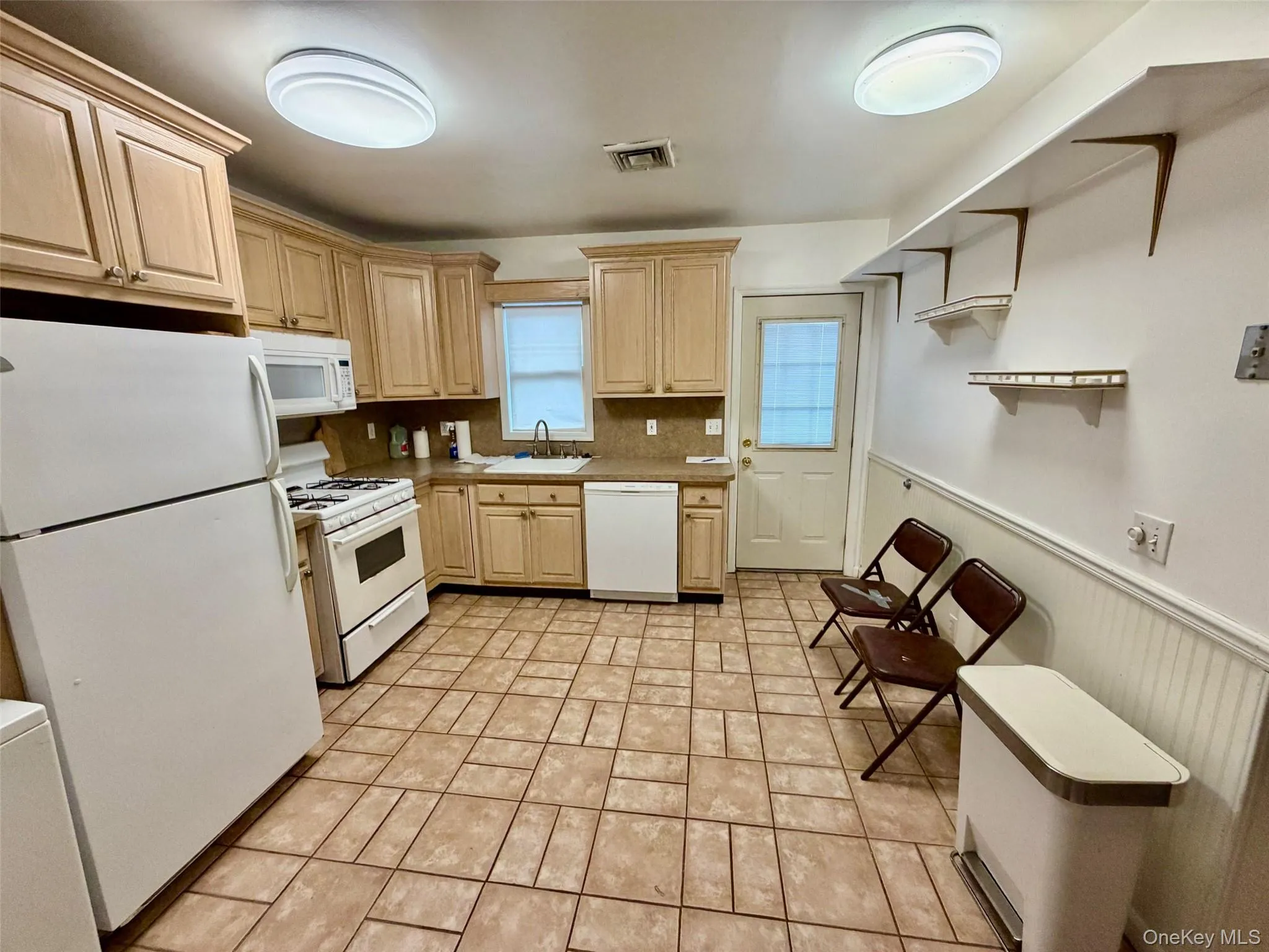 Kitchen featuring white appliances, light brown cabinetry, light countertops, tasteful backsplash, and open shelves Kitchen featuring white appliances, light brown cabinetry, light countertops, tasteful backsplash, and open shelves