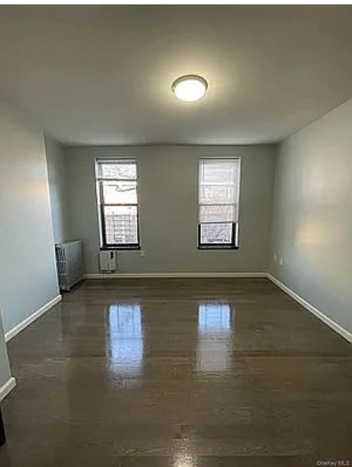 Spare room with healthy amount of natural light and radiator heating unit Spare room with healthy amount of natural light and radiator heating unit