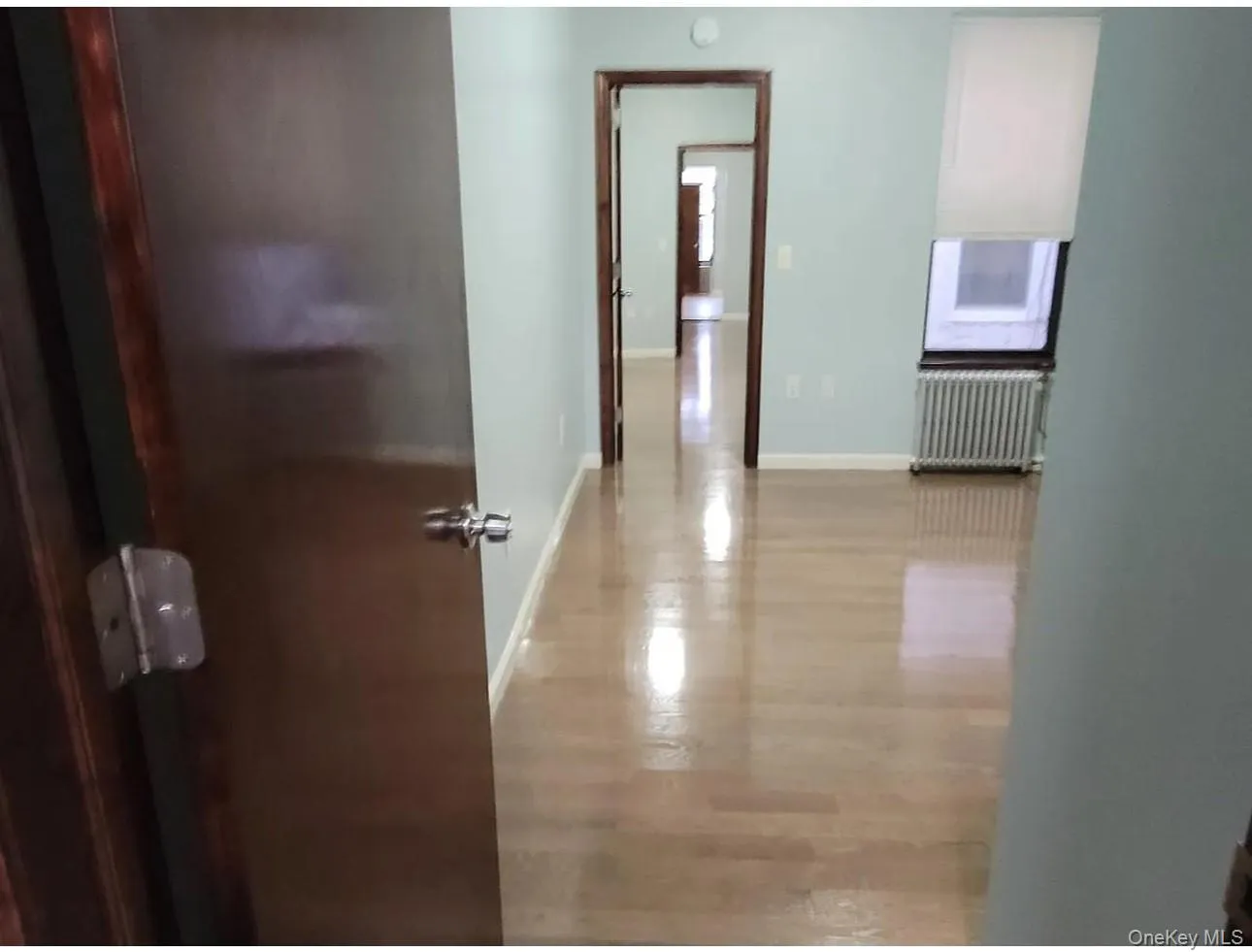 Hallway with radiator heating unit and light wood-style flooring Hallway with radiator heating unit and light wood-style flooring