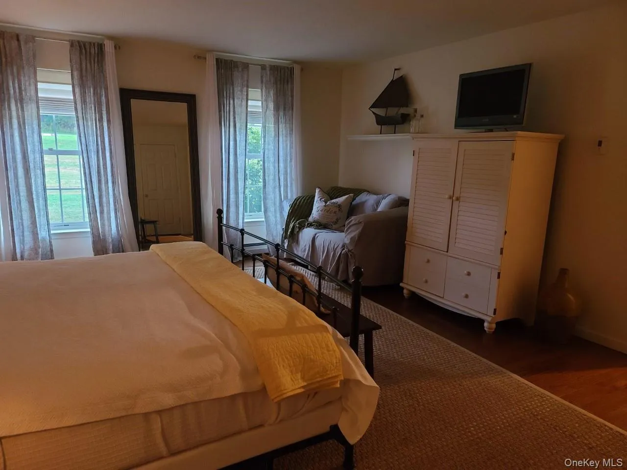 Bedroom featuring dark wood finished floors and baseboards Bedroom featuring dark wood finished floors and baseboards