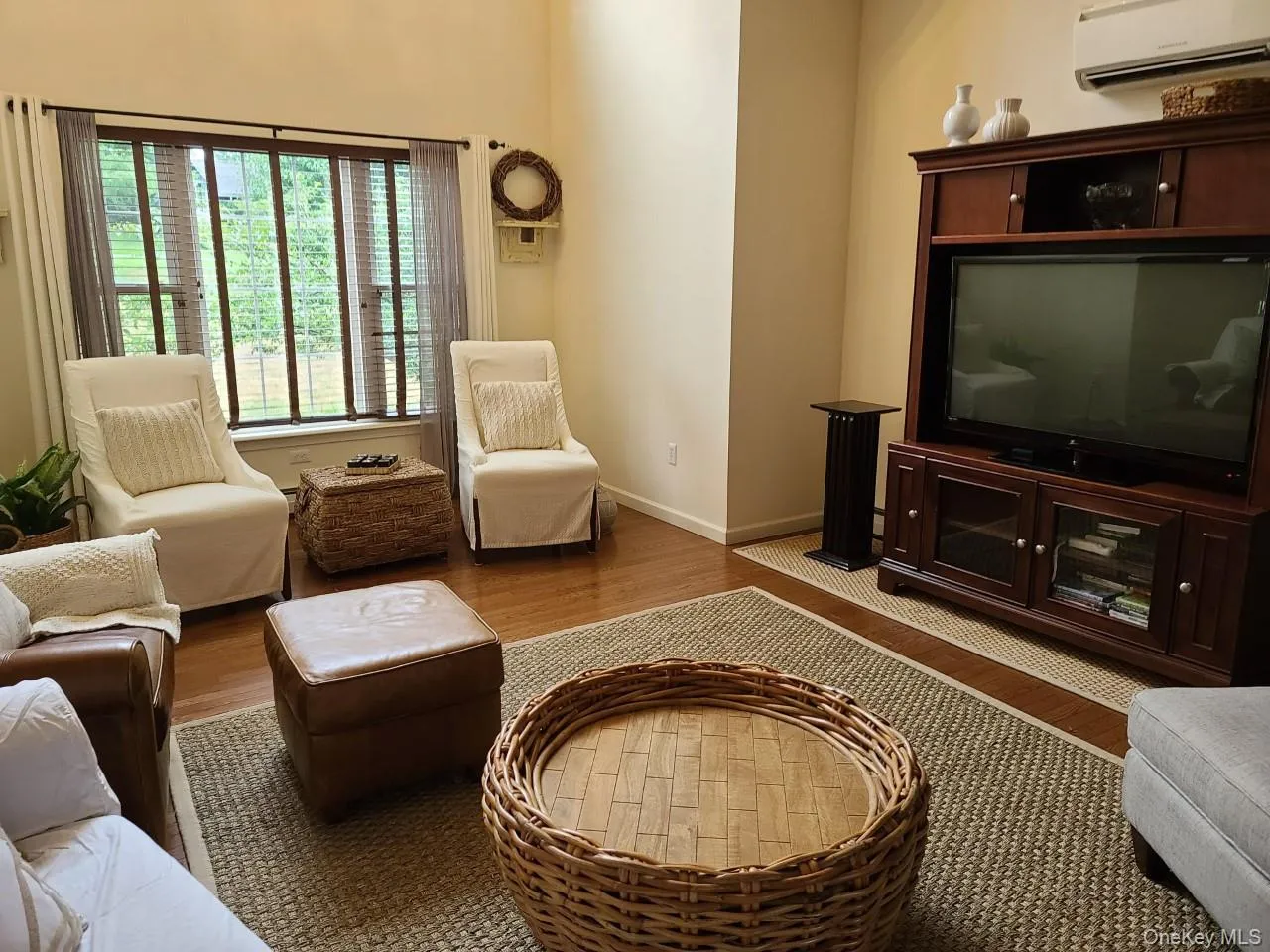 Living area featuring wood finished floors and a wall mounted AC Living area featuring wood finished floors and a wall mounted AC