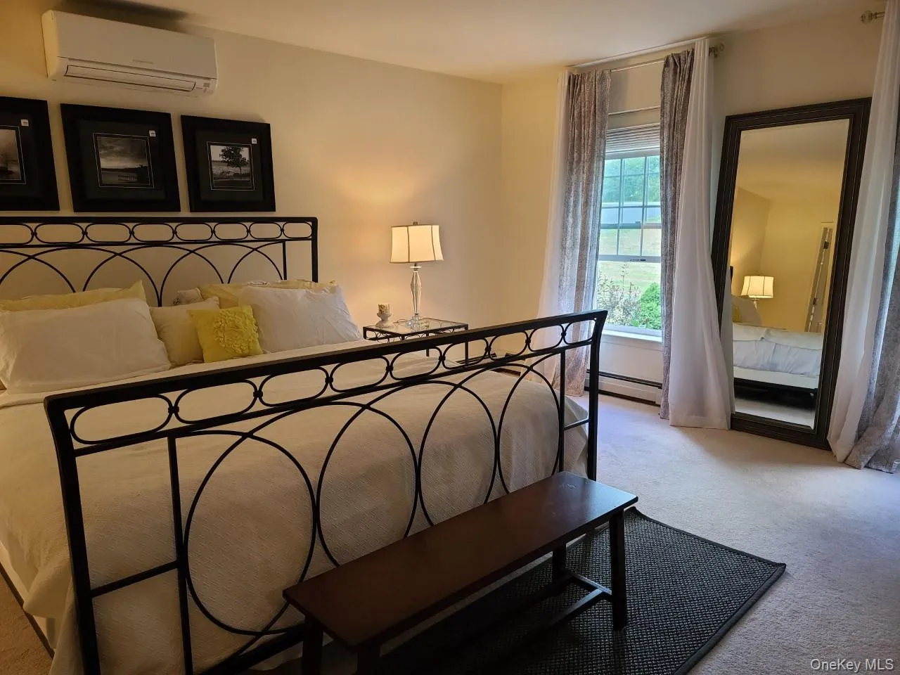 Bedroom with carpet, a wall mounted AC, and a baseboard radiator Bedroom with carpet, a wall mounted AC, and a baseboard radiator