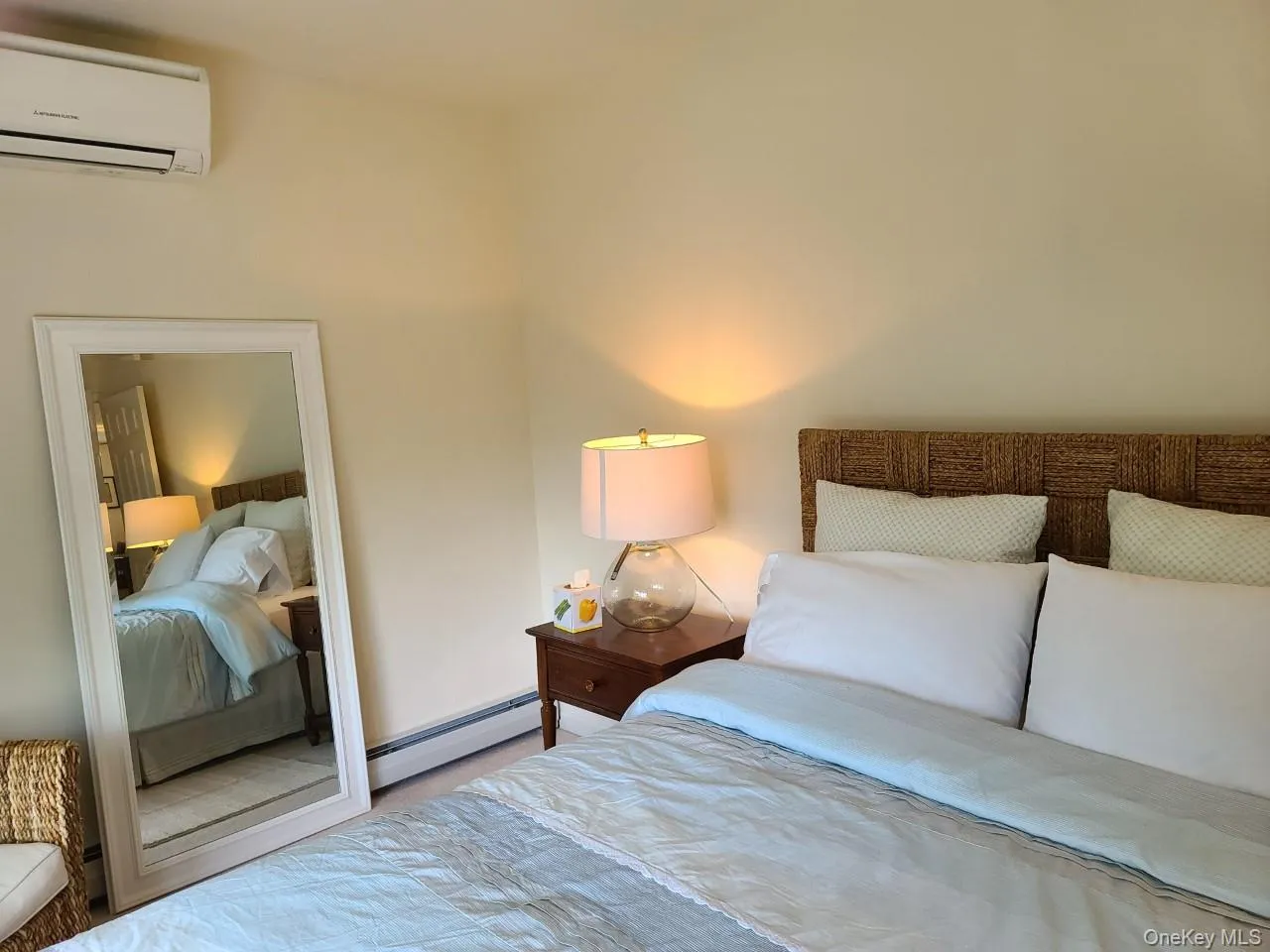 Bedroom with carpet floors, a wall unit AC, and baseboard heating Bedroom with carpet floors, a wall unit AC, and baseboard heating