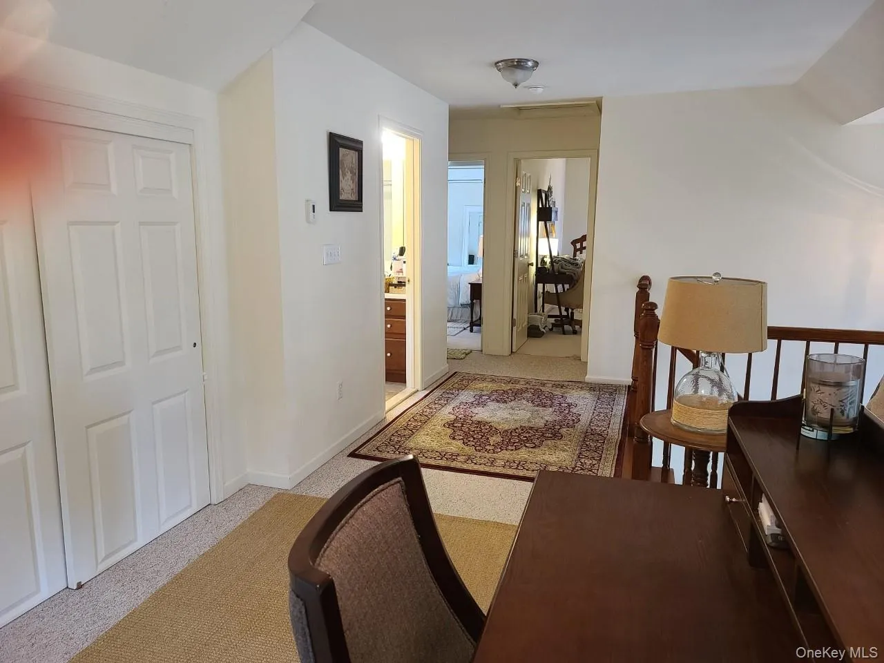 Corridor featuring light carpet and lots of closets Corridor featuring light carpet and lots of closets