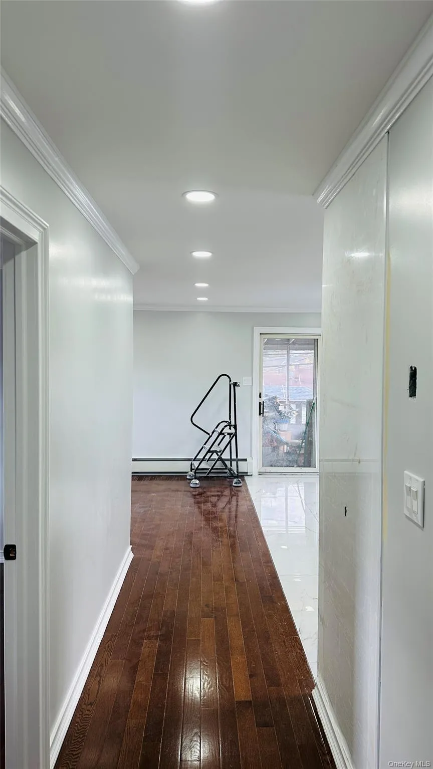 Corridor featuring hardwood / wood-style flooring, crown molding, a baseboard radiator, and recessed lighting Corridor featuring hardwood / wood-style flooring, crown molding, a baseboard radiator, and recessed lighting