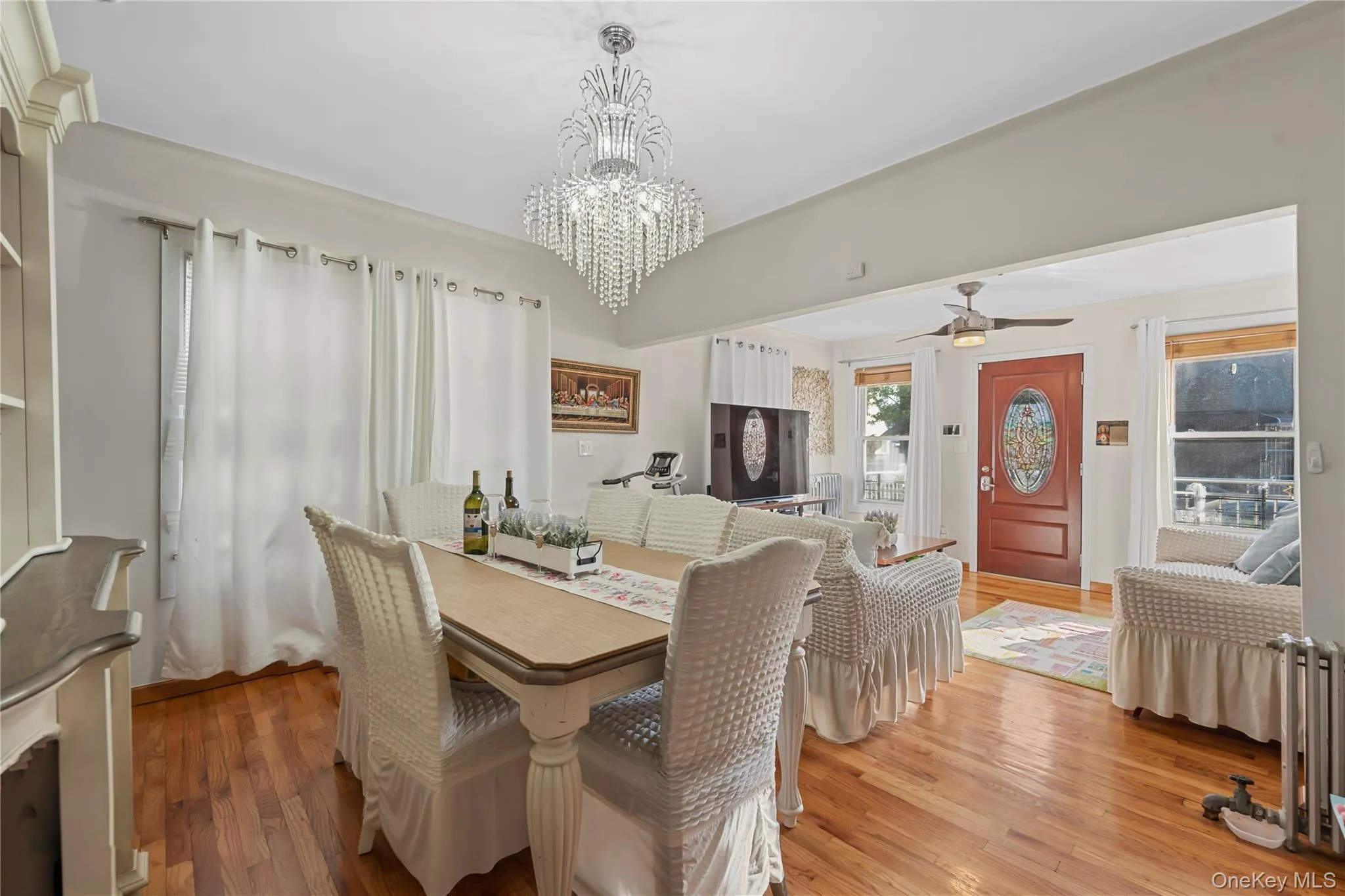 Dining room featuring wood finished floors, a chandelier, and ceiling fan Dining room featuring wood finished floors, a chandelier, and ceiling fan