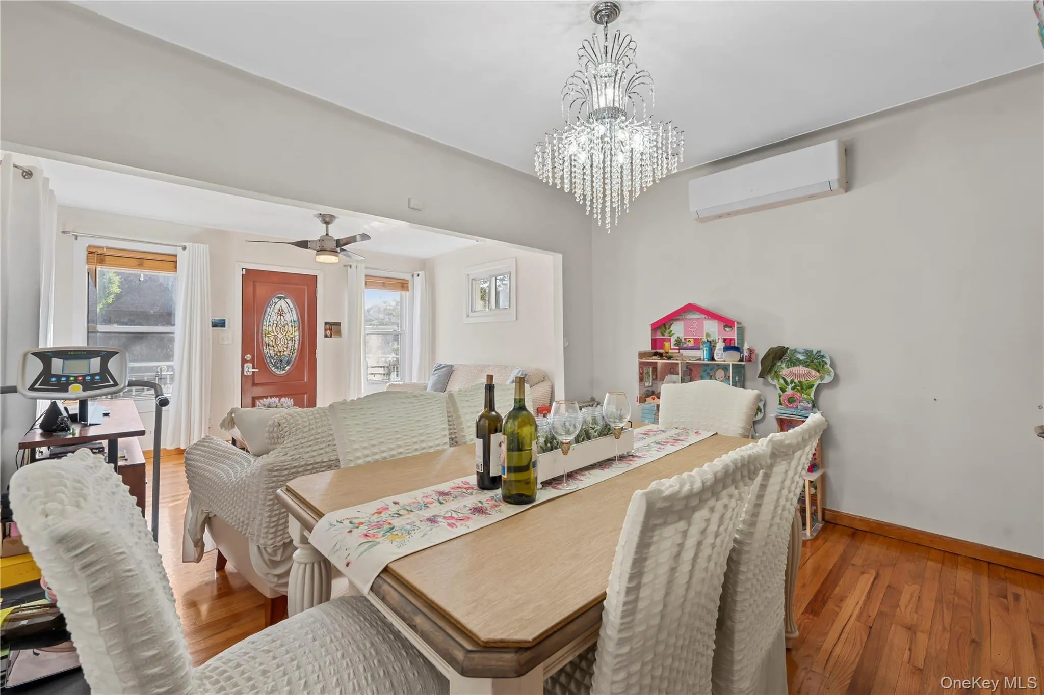 Dining area featuring wood finished floors, plenty of natural light, and a wall mounted AC Dining area featuring wood finished floors, plenty of natural light, and a wall mounted AC