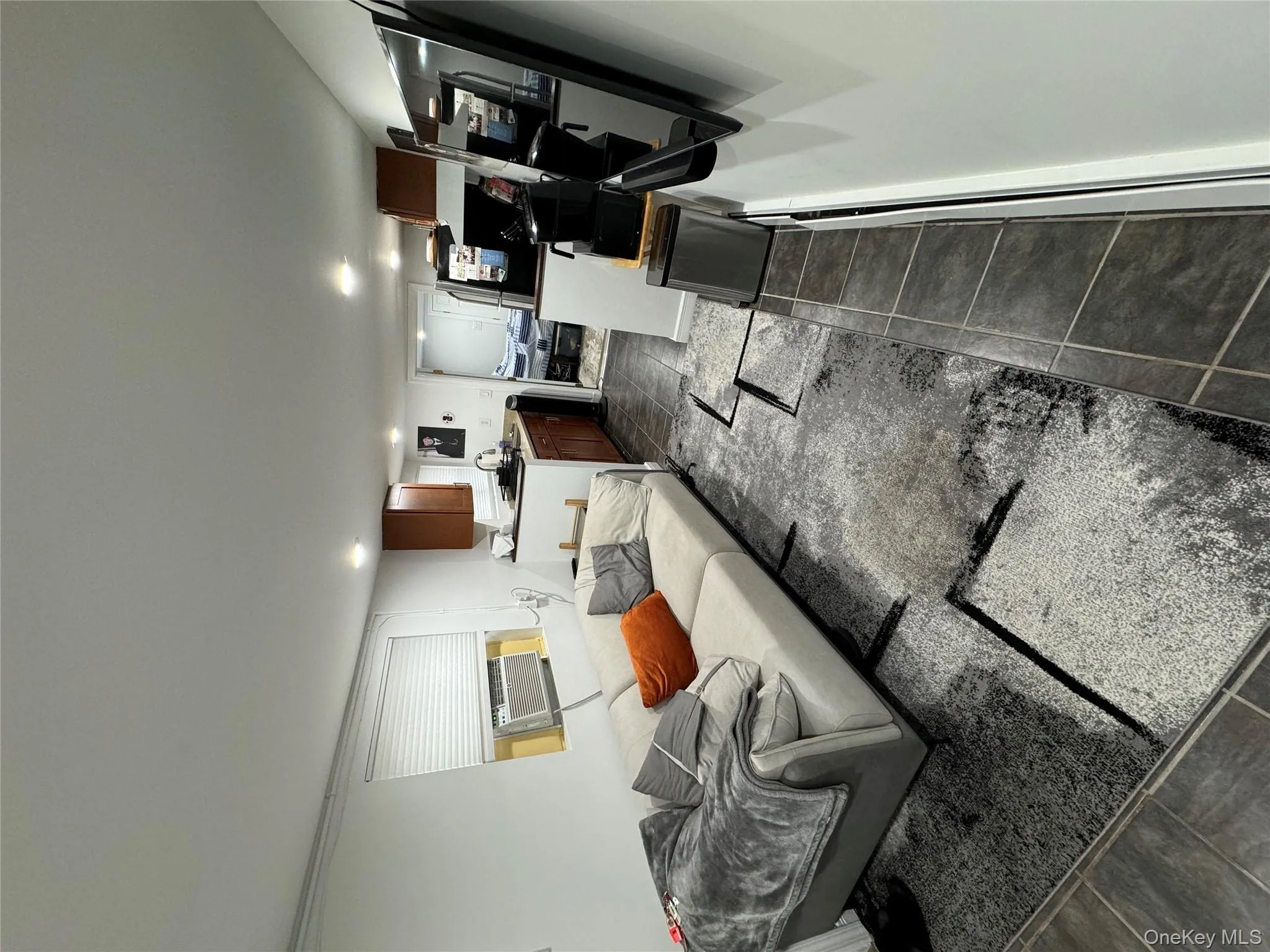 Living room with dark tile patterned flooring and recessed lighting Living room with dark tile patterned flooring and recessed lighting