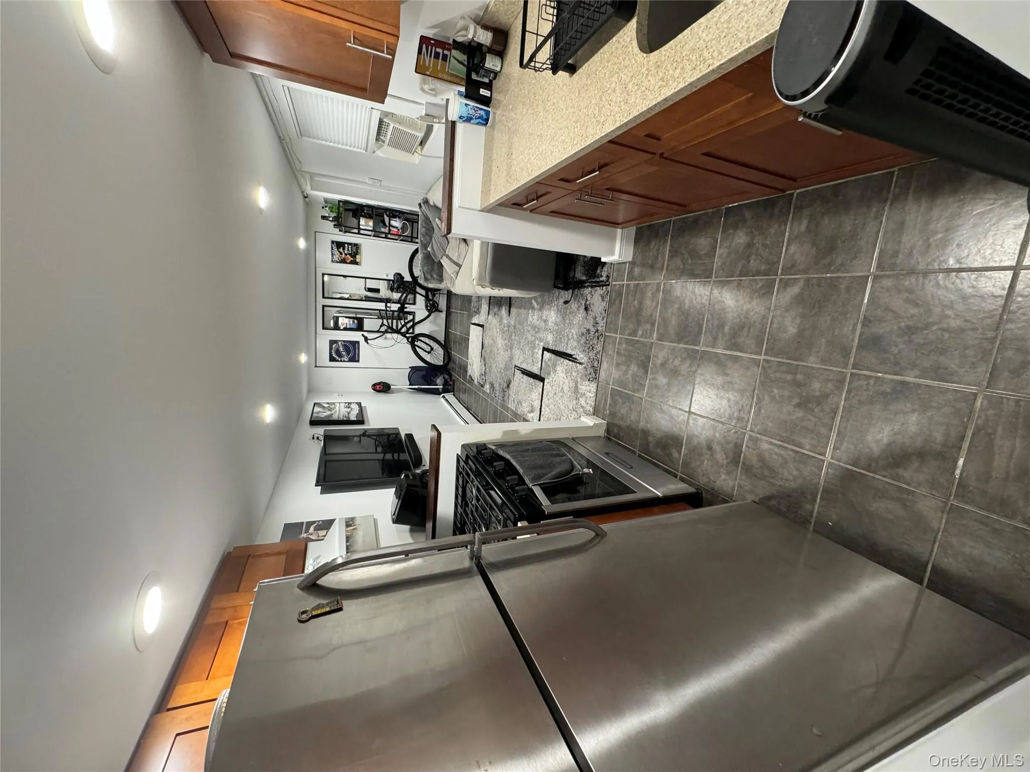 Kitchen with brown cabinets, fridge, open floor plan, range, and recessed lighting Kitchen with brown cabinets, fridge, open floor plan, range, and recessed lighting