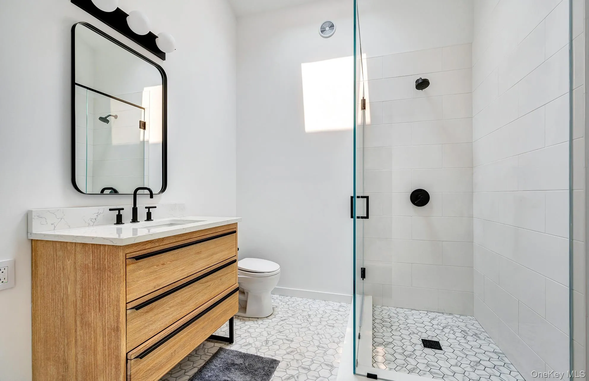 Full bath featuring vanity, a shower stall, and light tile patterned floors Full bath featuring vanity, a shower stall, and light tile patterned floors