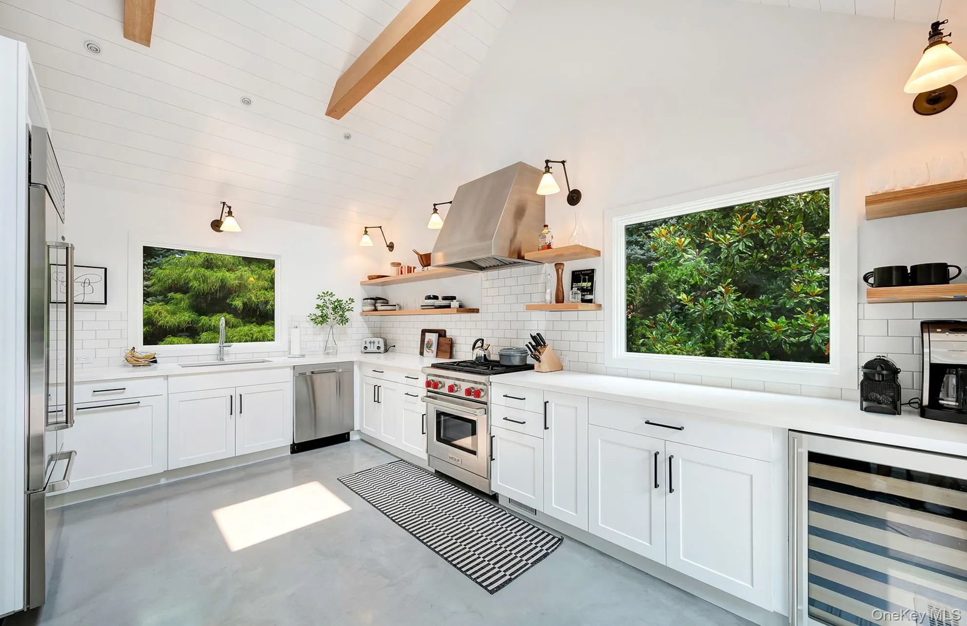 Kitchen with white cabinets, backsplash, beverage cooler, open shelves, and beamed ceiling Kitchen with white cabinets, backsplash, beverage cooler, open shelves, and beamed ceiling