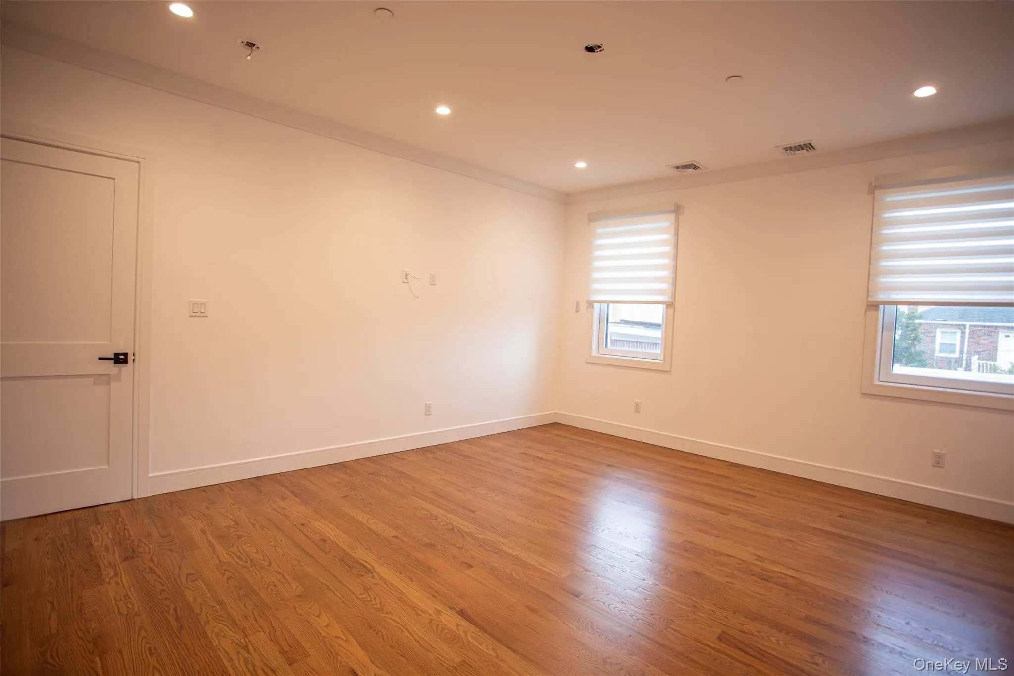 Spare room with crown molding, wood finished floors, and recessed lighting Spare room with crown molding, wood finished floors, and recessed lighting