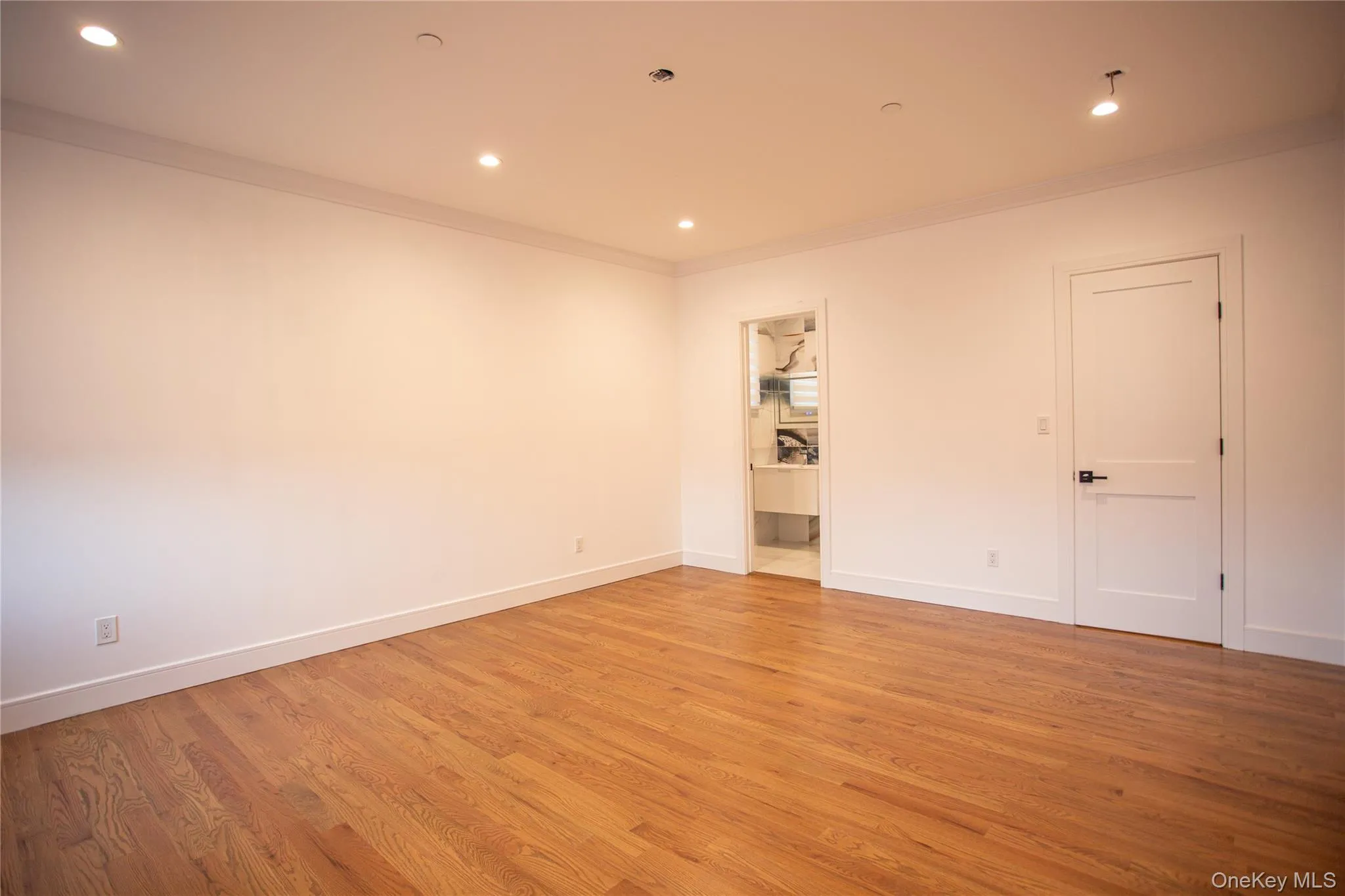 Empty room featuring crown molding, recessed lighting, and light wood-style floors Empty room featuring crown molding, recessed lighting, and light wood-style floors