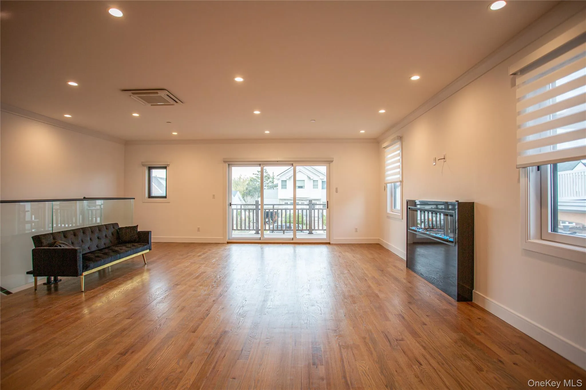 Living room featuring crown molding, recessed lighting, plenty of natural light, and light wood-style flooring Living room featuring crown molding, recessed lighting, plenty of natural light, and light wood-style flooring