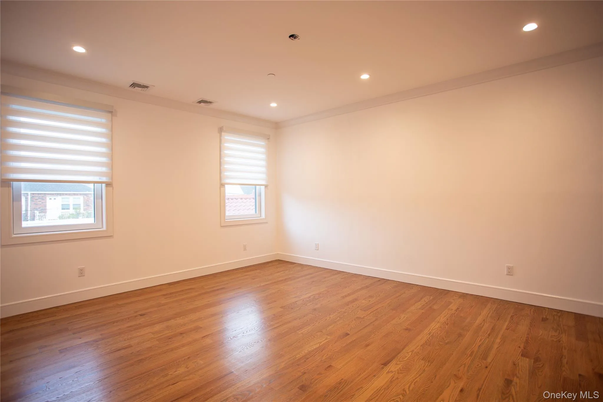 Spare room with ornamental molding, light wood-style floors, and recessed lighting Spare room with ornamental molding, light wood-style floors, and recessed lighting