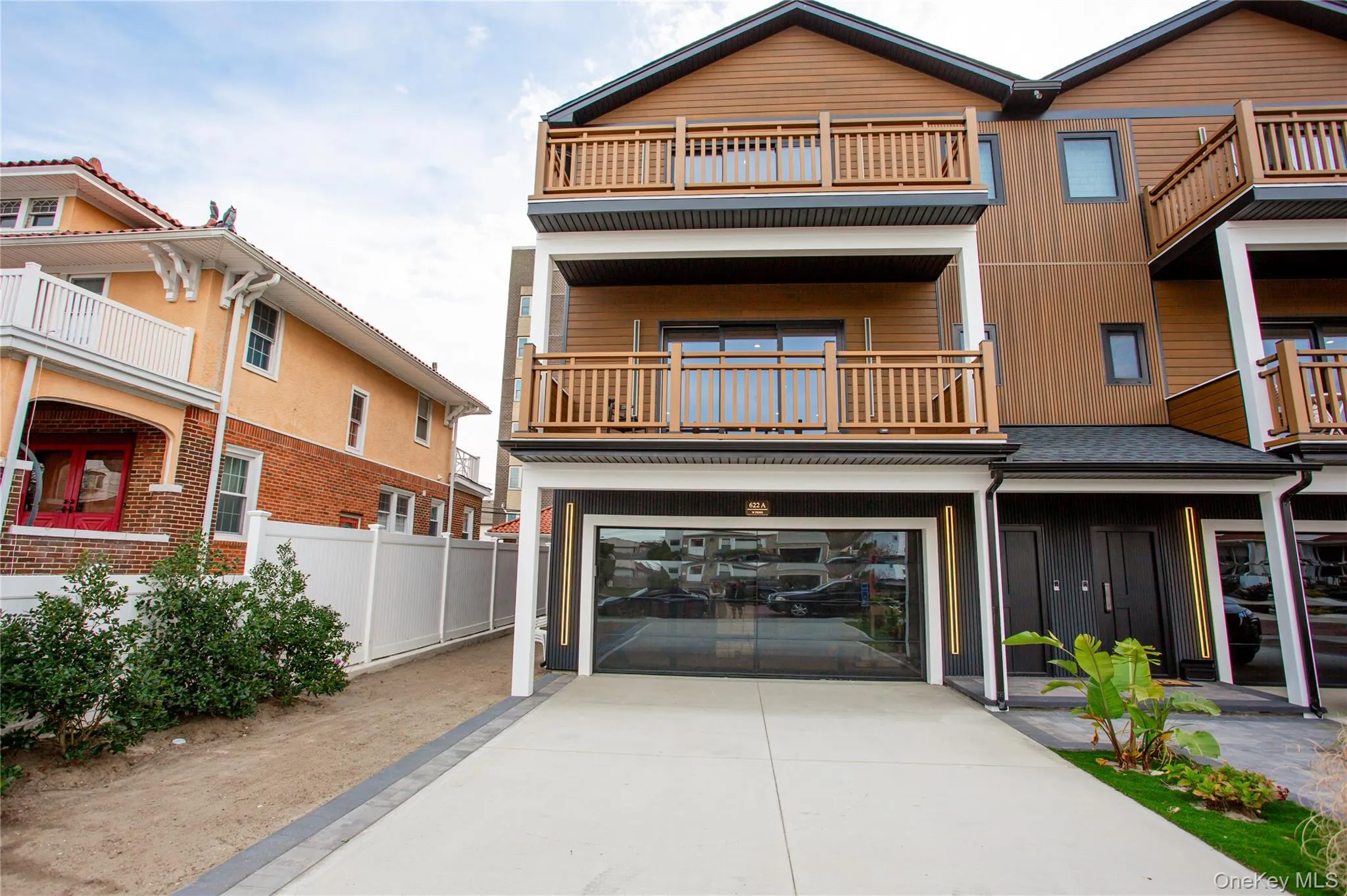 View of front of property featuring concrete driveway, a garage, a balcony, and a patio View of front of property featuring concrete driveway, a garage, a balcony, and a patio