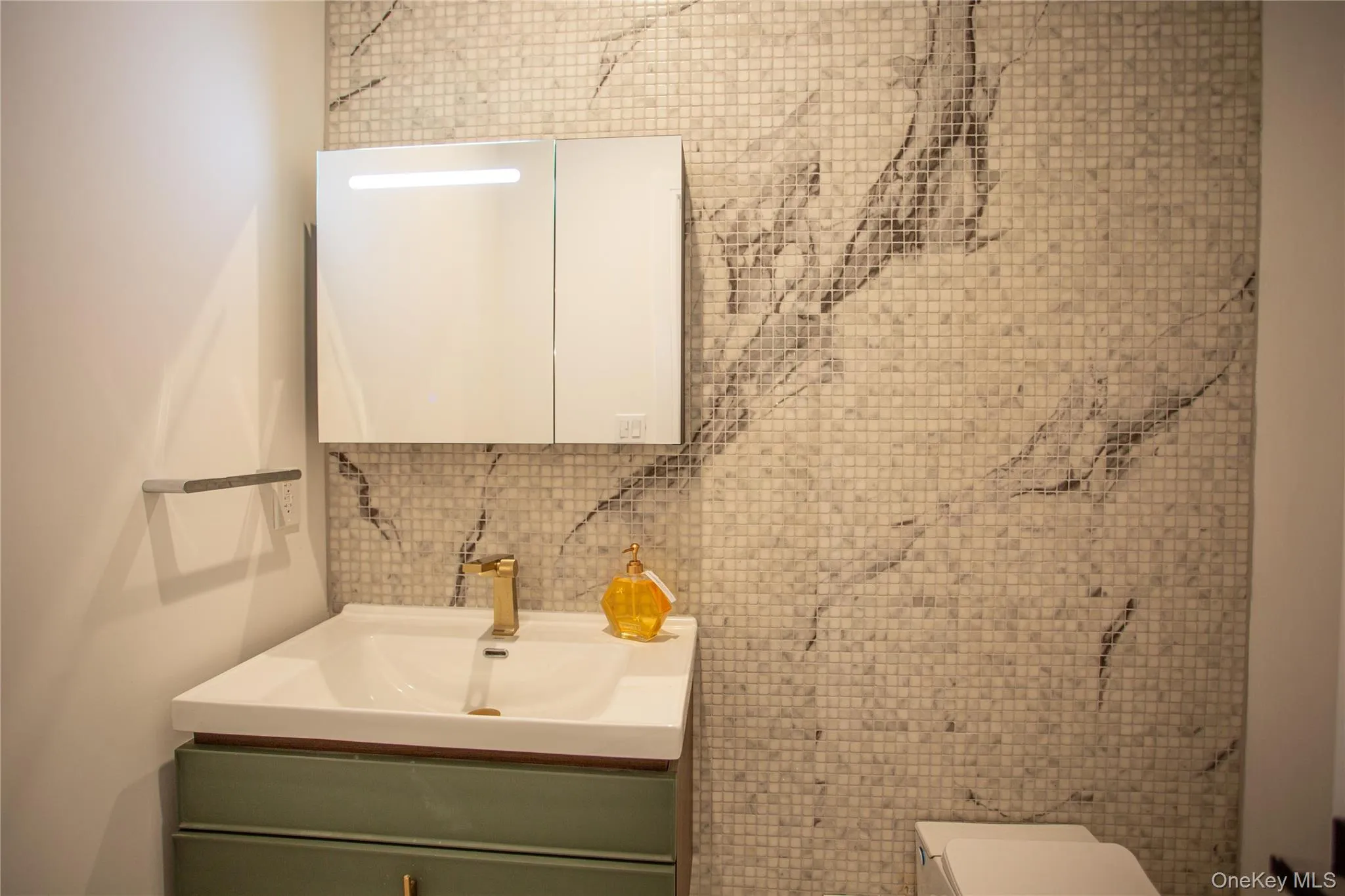 Half bath featuring tile walls, vanity, and decorative backsplash Half bath featuring tile walls, vanity, and decorative backsplash